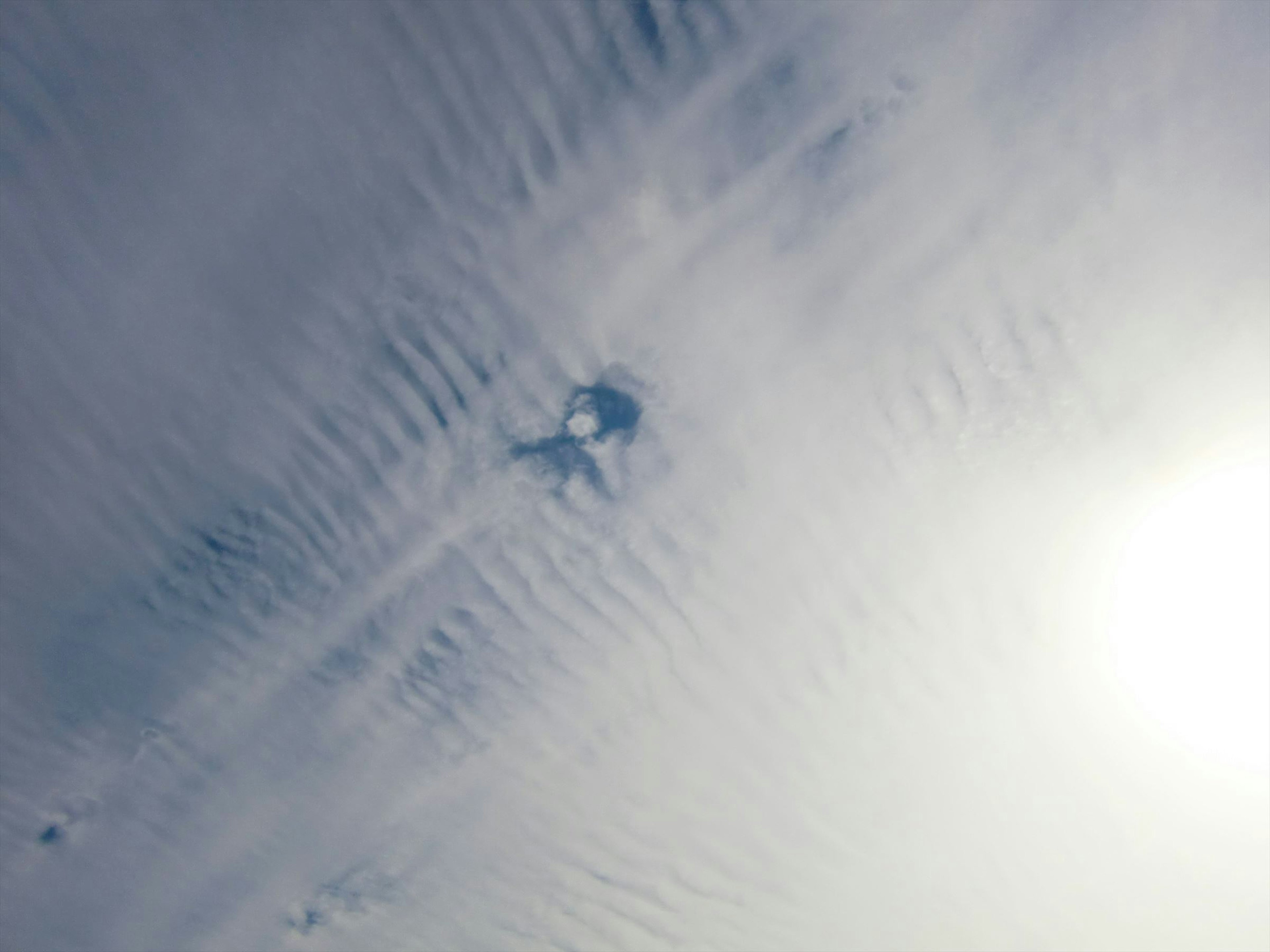 Tache bleue dans le ciel avec des motifs de nuages et de la lumière du soleil