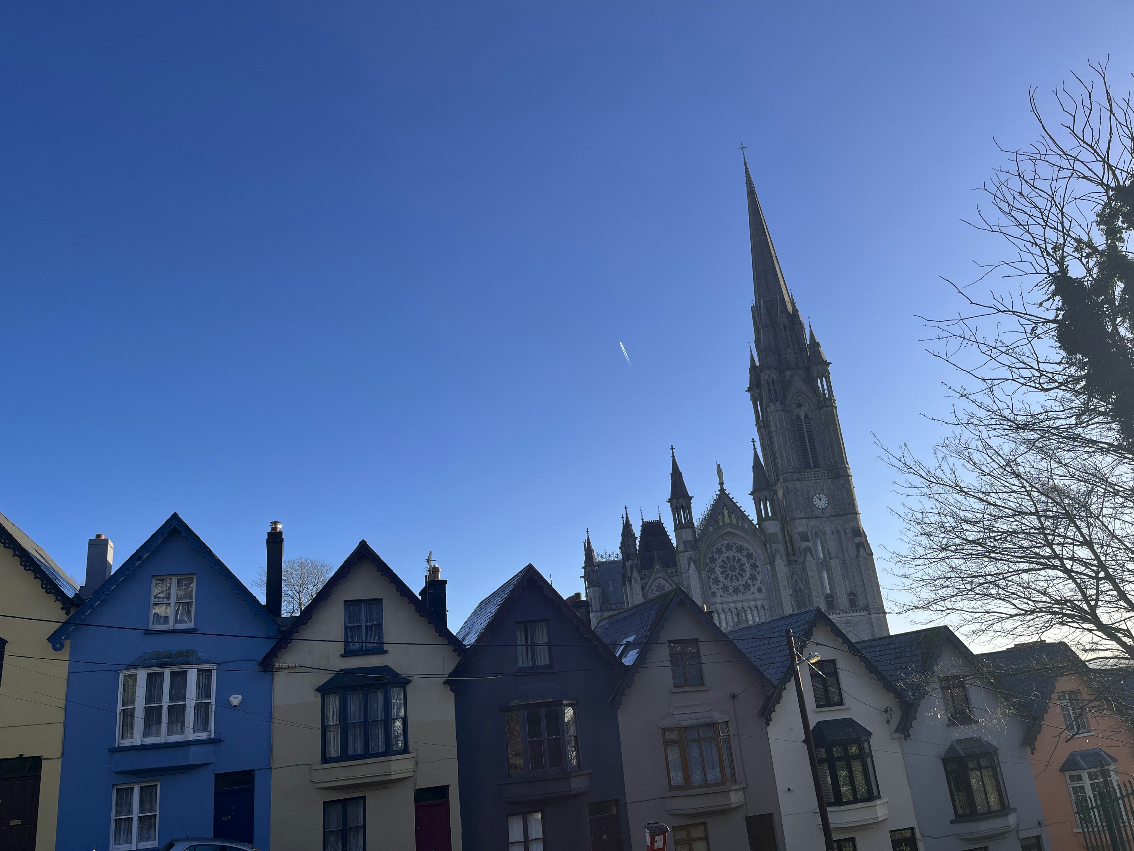 Bright blue sky with colorful houses and a historic church tower