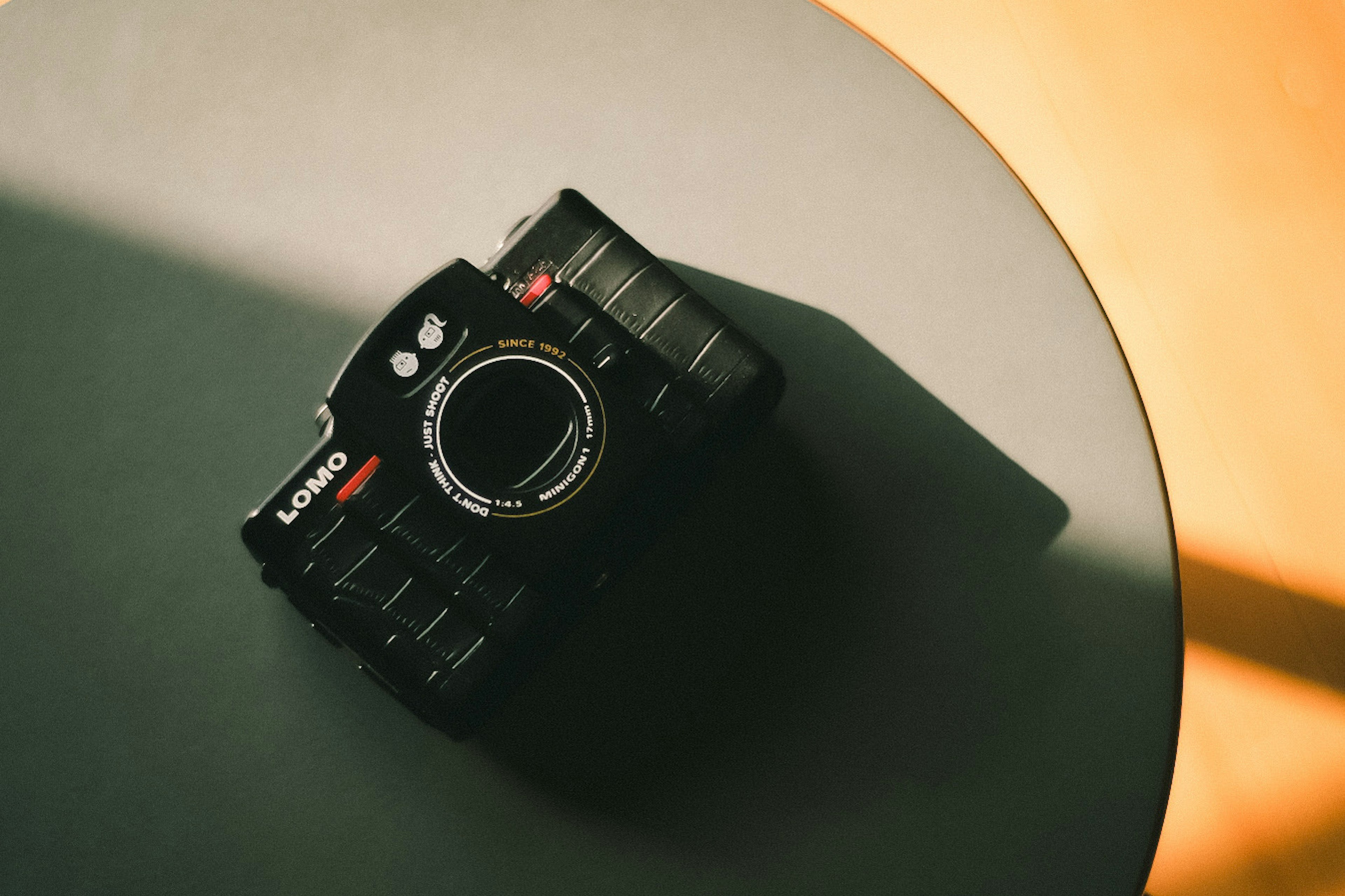 Un appareil photo noir posé sur une table ronde