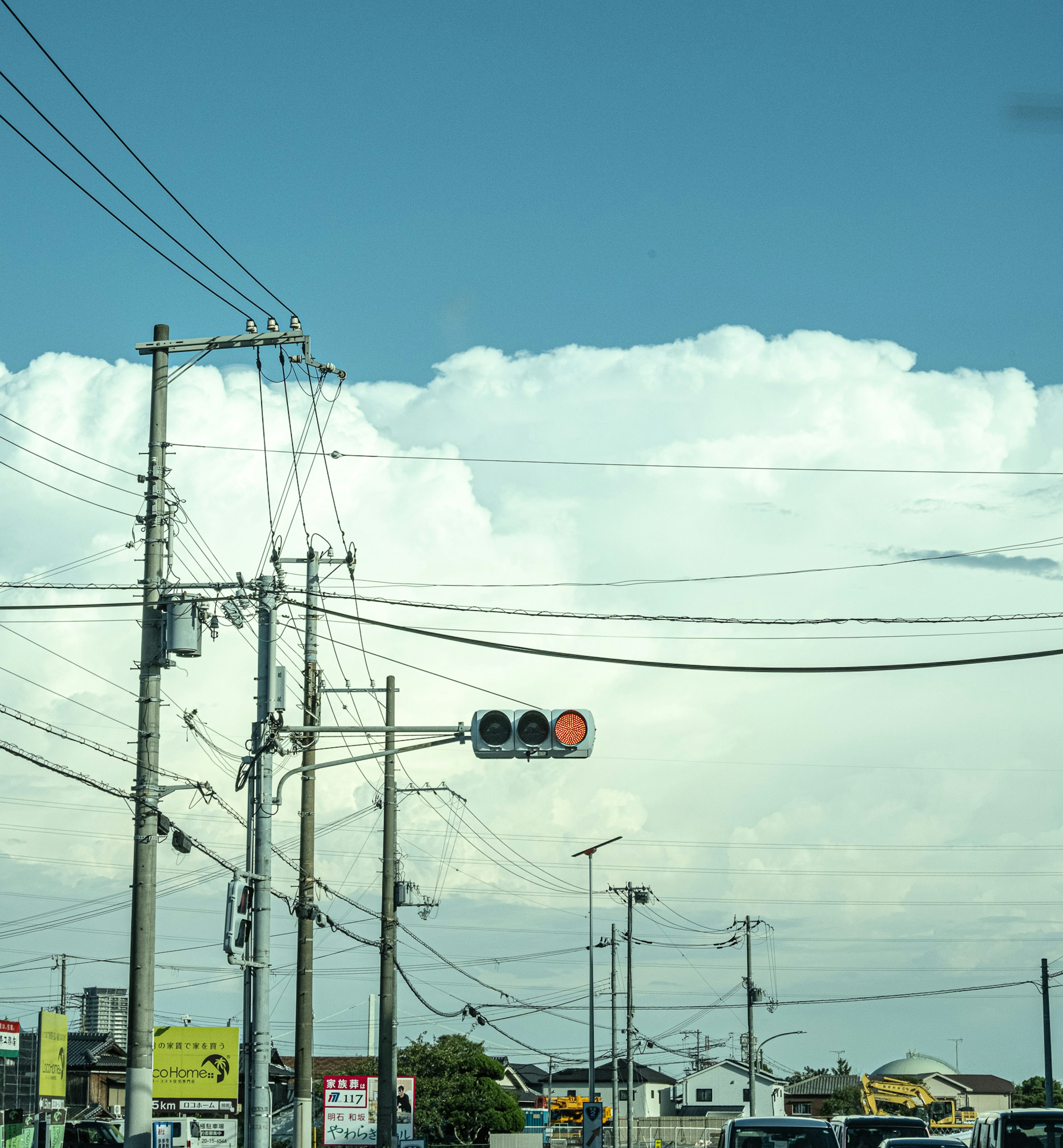 Lampu lalu lintas dan tiang listrik di bawah langit biru