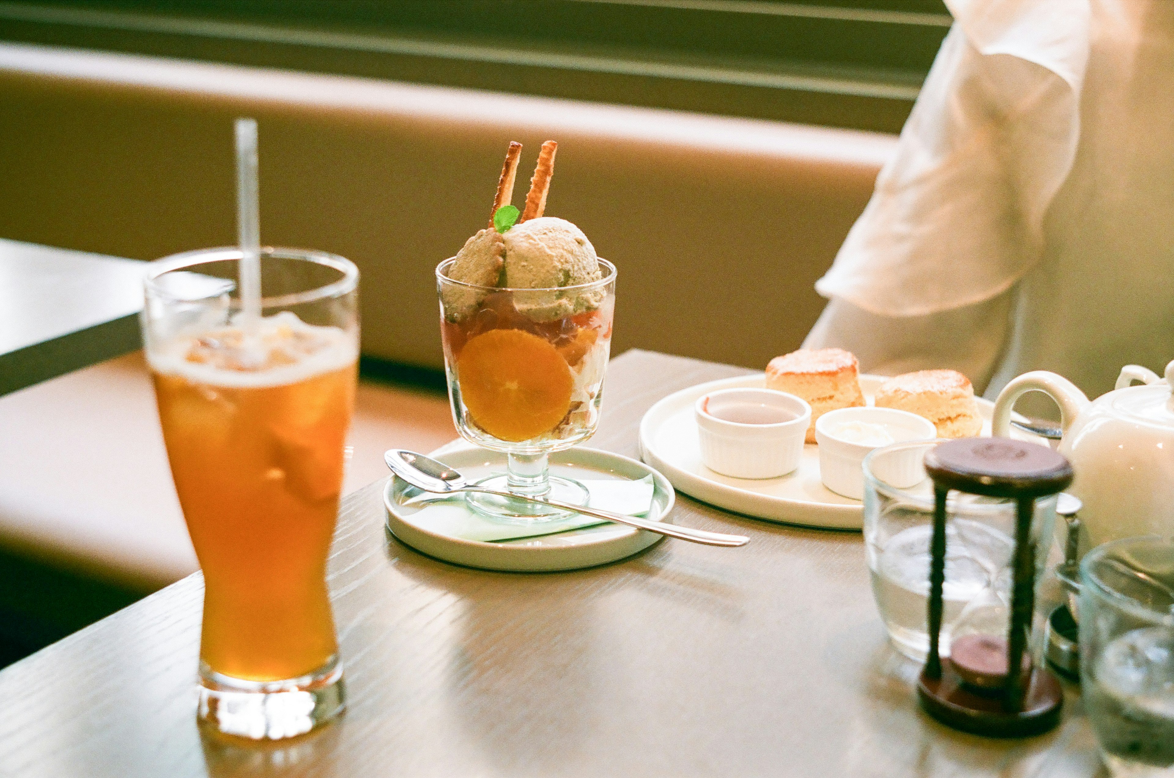 A scene of a table with iced tea and a dessert sundae