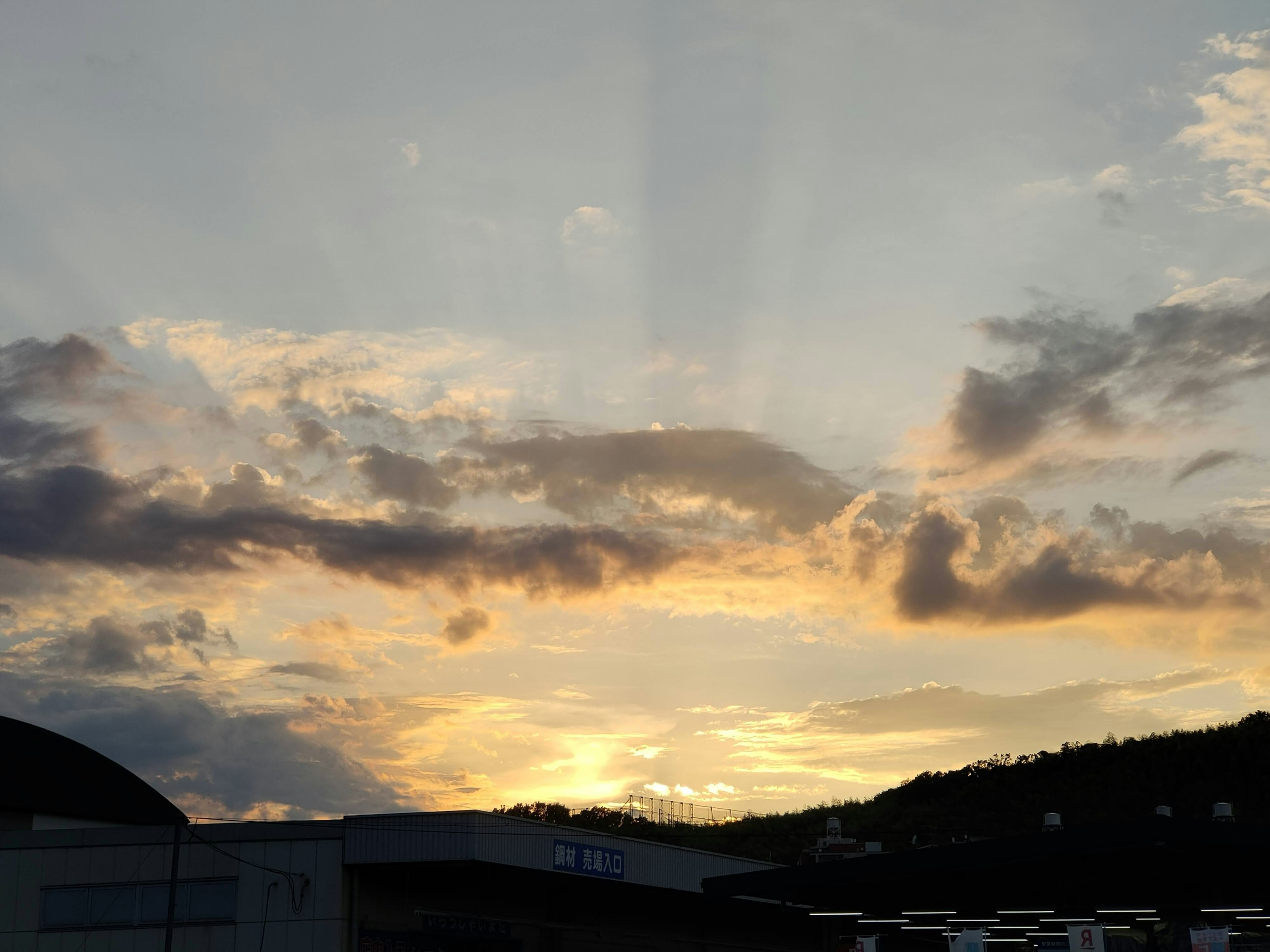 Bellissimo paesaggio al tramonto con nuvole e raggi