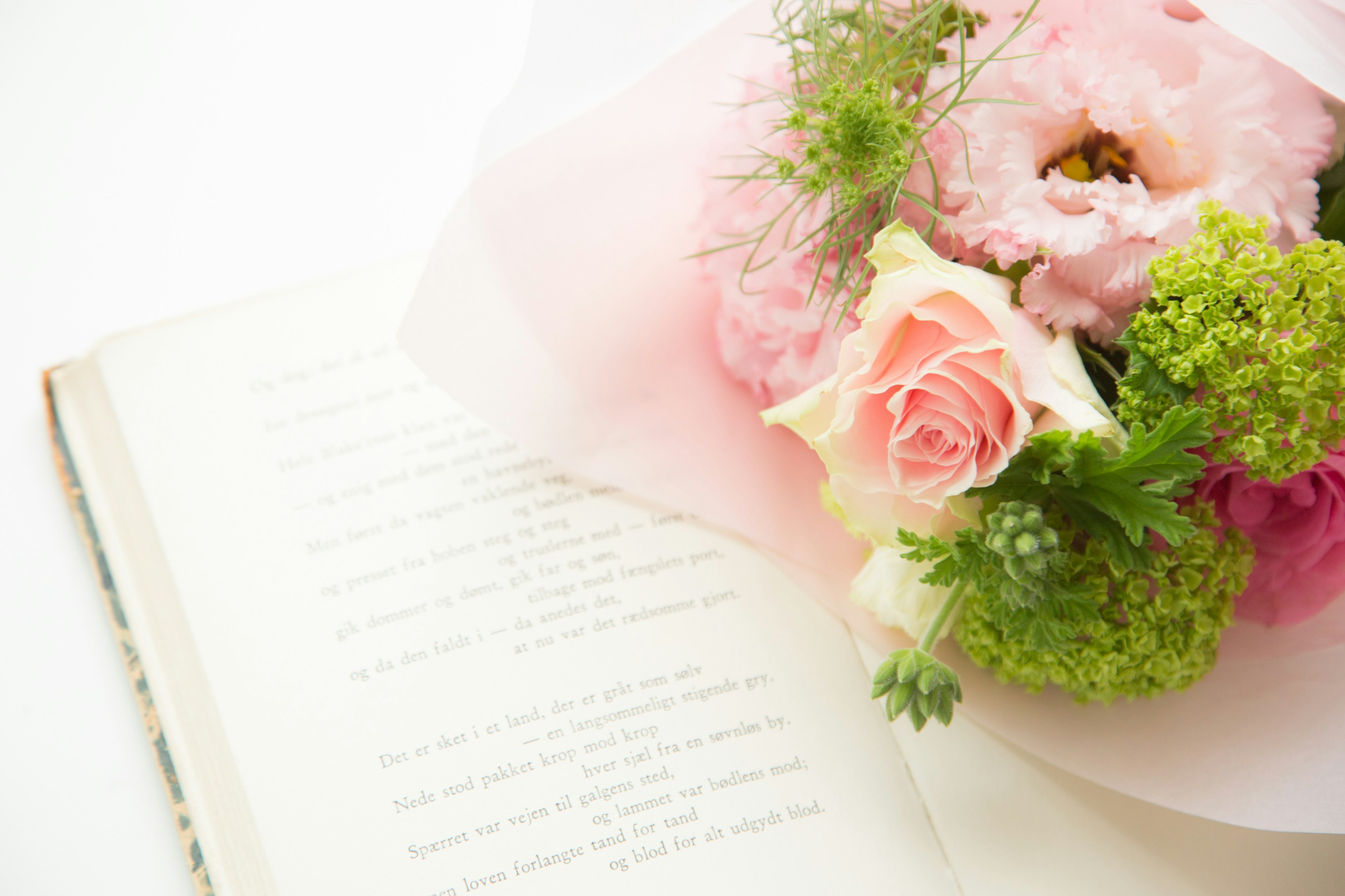 A beautiful scene featuring a bouquet of flowers beside an open book