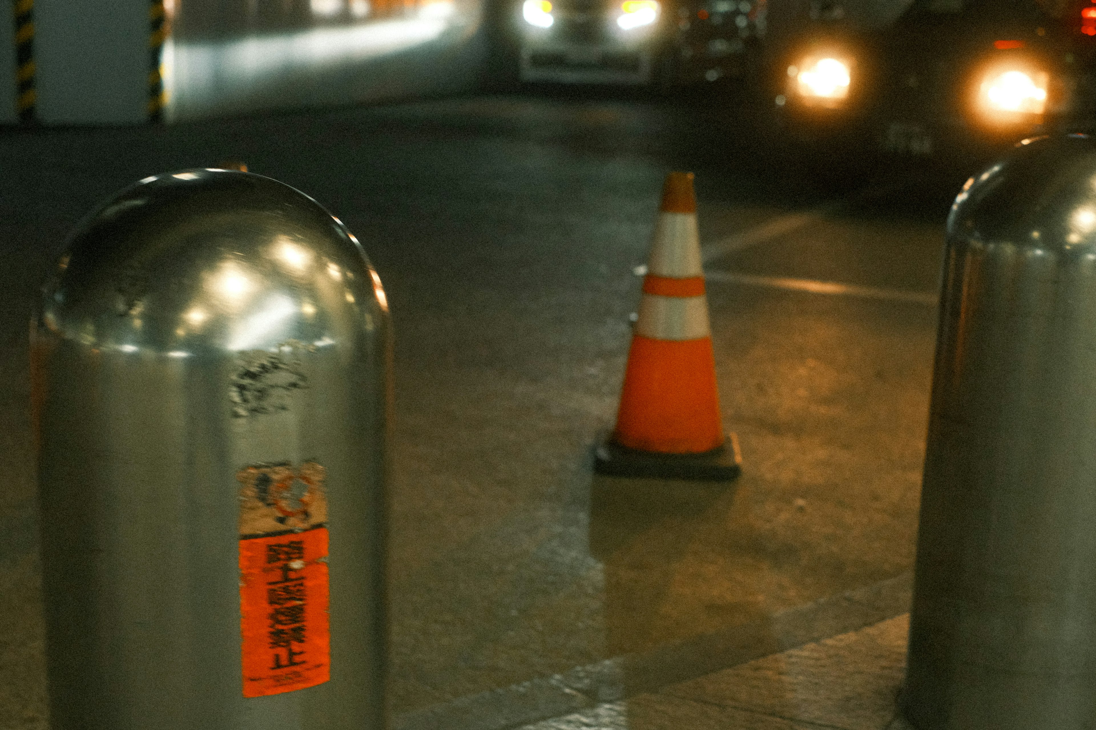 Tempat parkir dengan bollard logam dan cone lalu lintas oranye