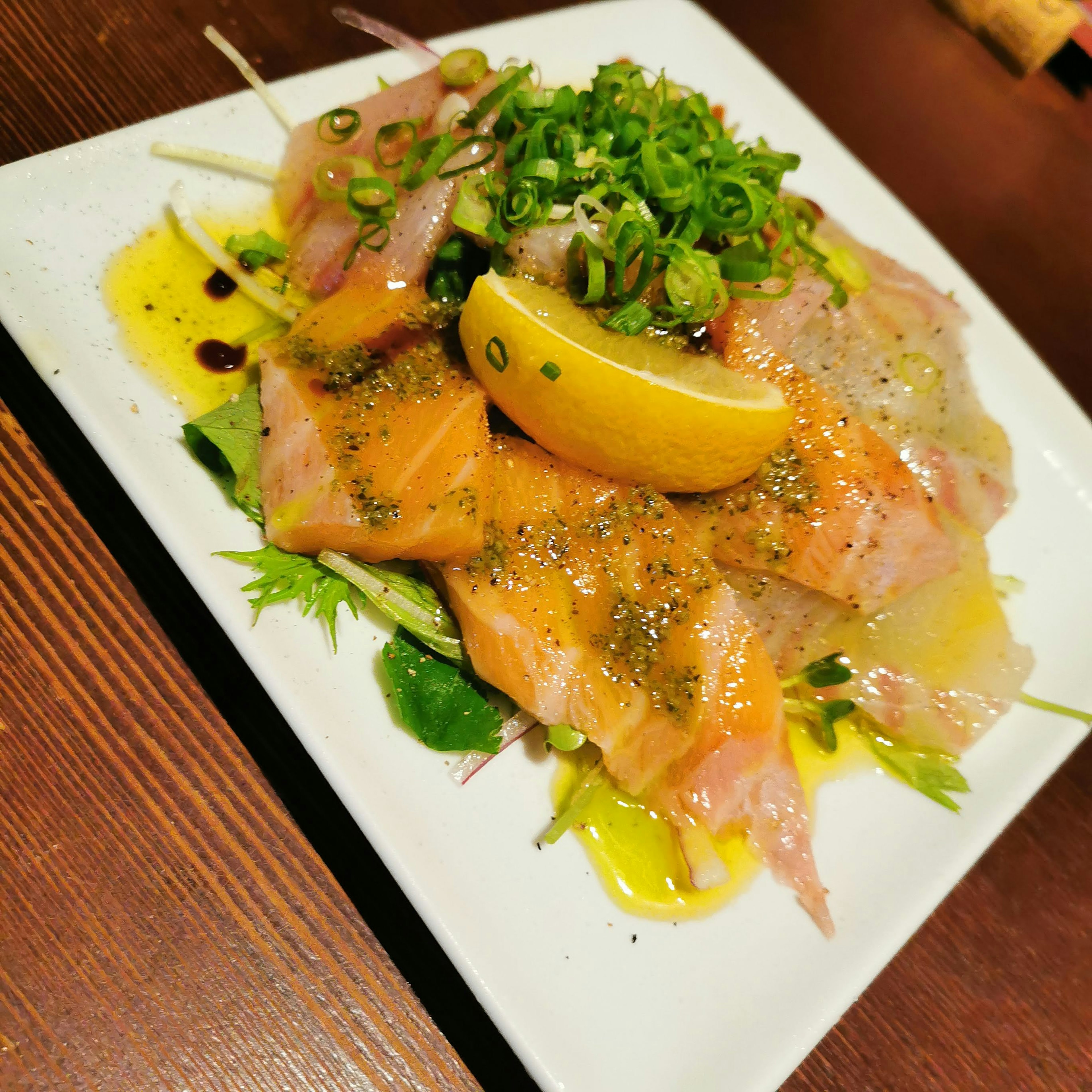 Plato de salmón y verduras decorado con limón y cebollines