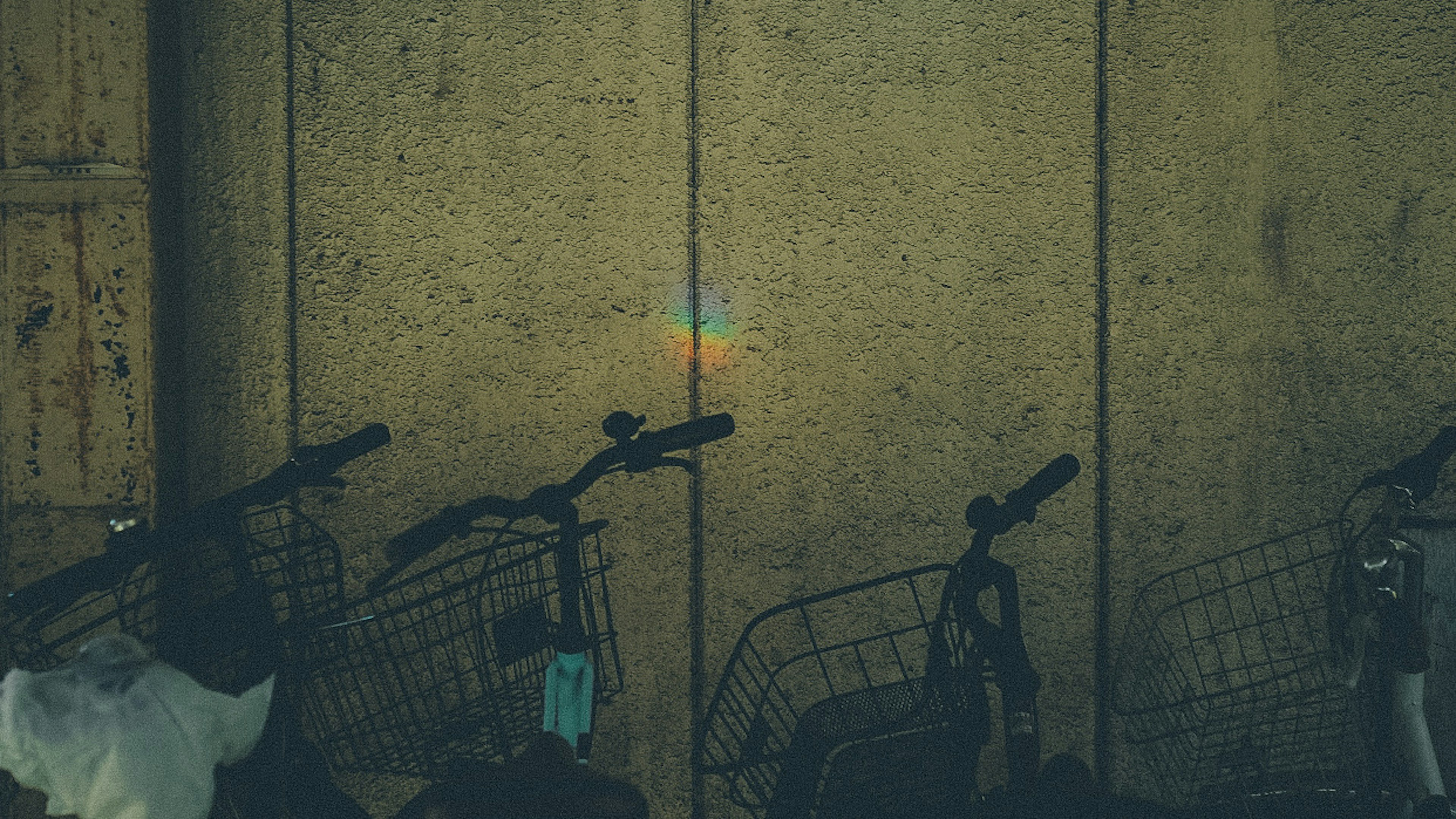 Rainbow light reflection on the wall with a group of bicycles