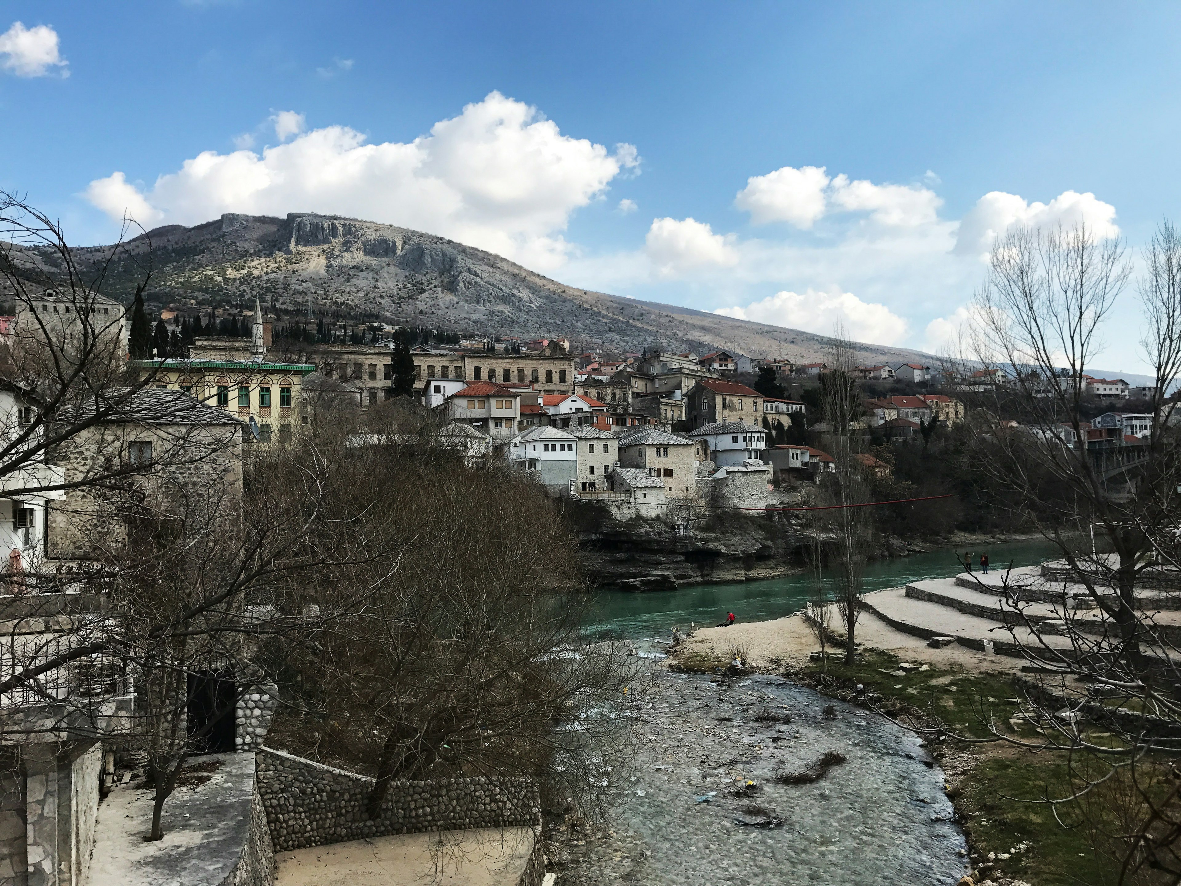 Vista panoramica di una piccola città lungo un fiume con montagne sullo sfondo