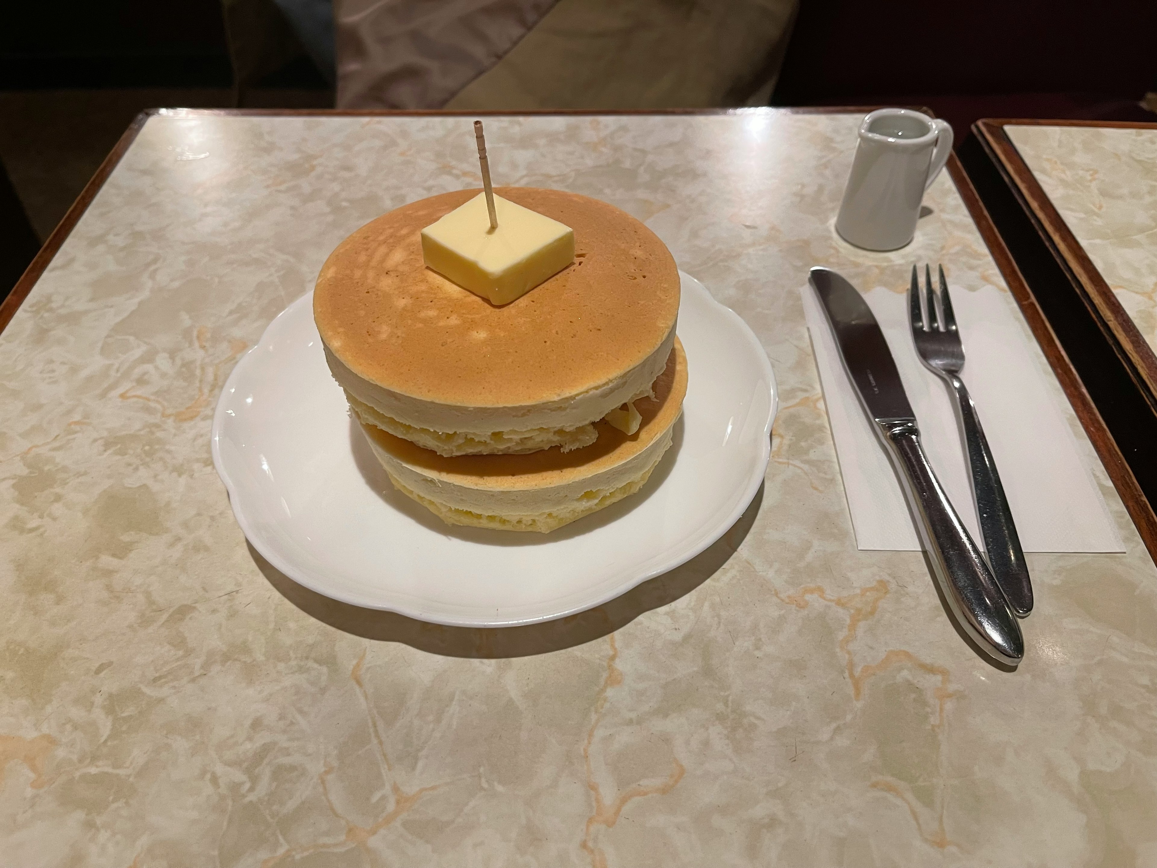 Fluffy pancakes stacked with a slice of butter on top