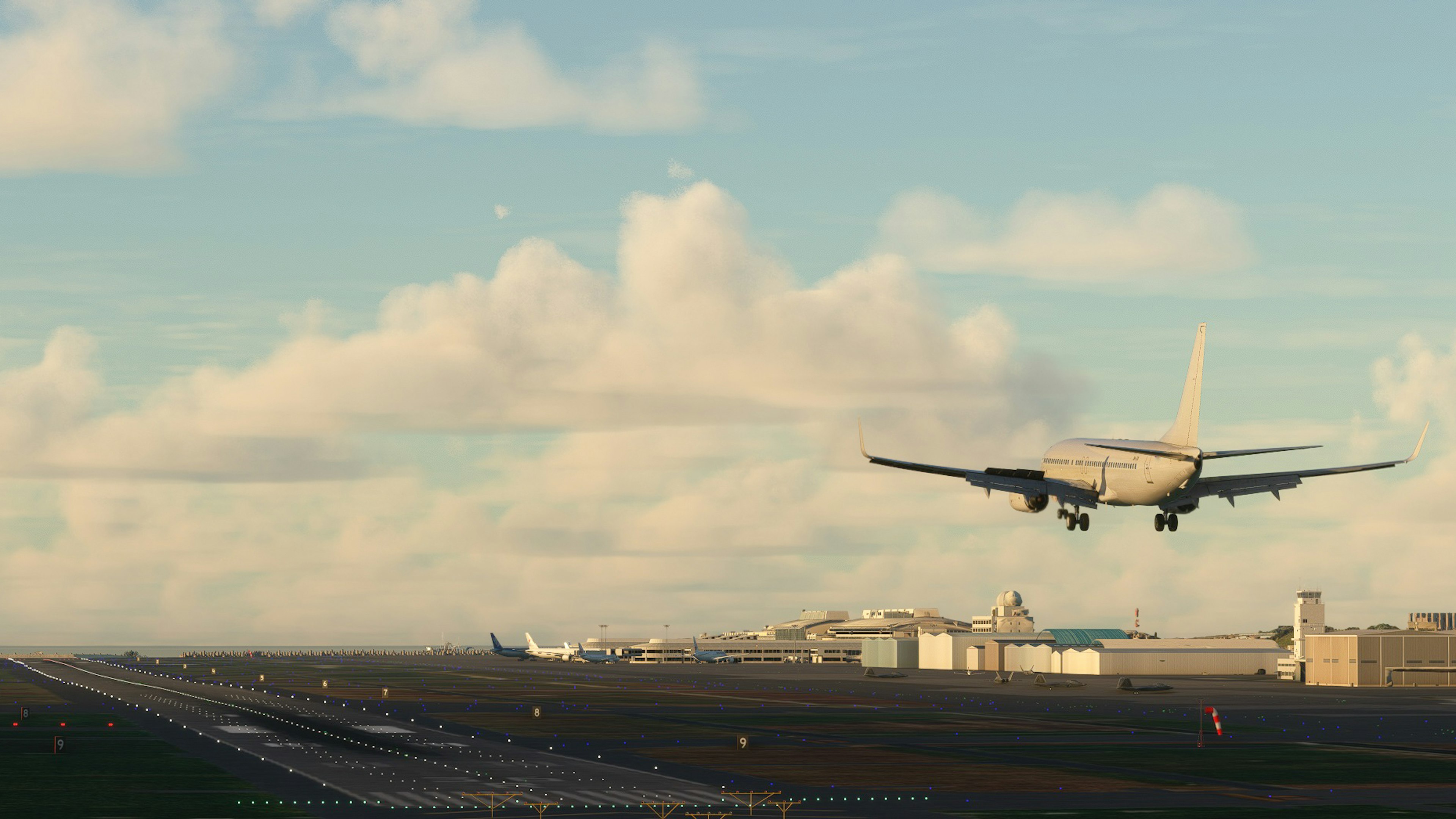 Flugzeug landet auf einer Landebahn mit Wolken im blauen Himmel