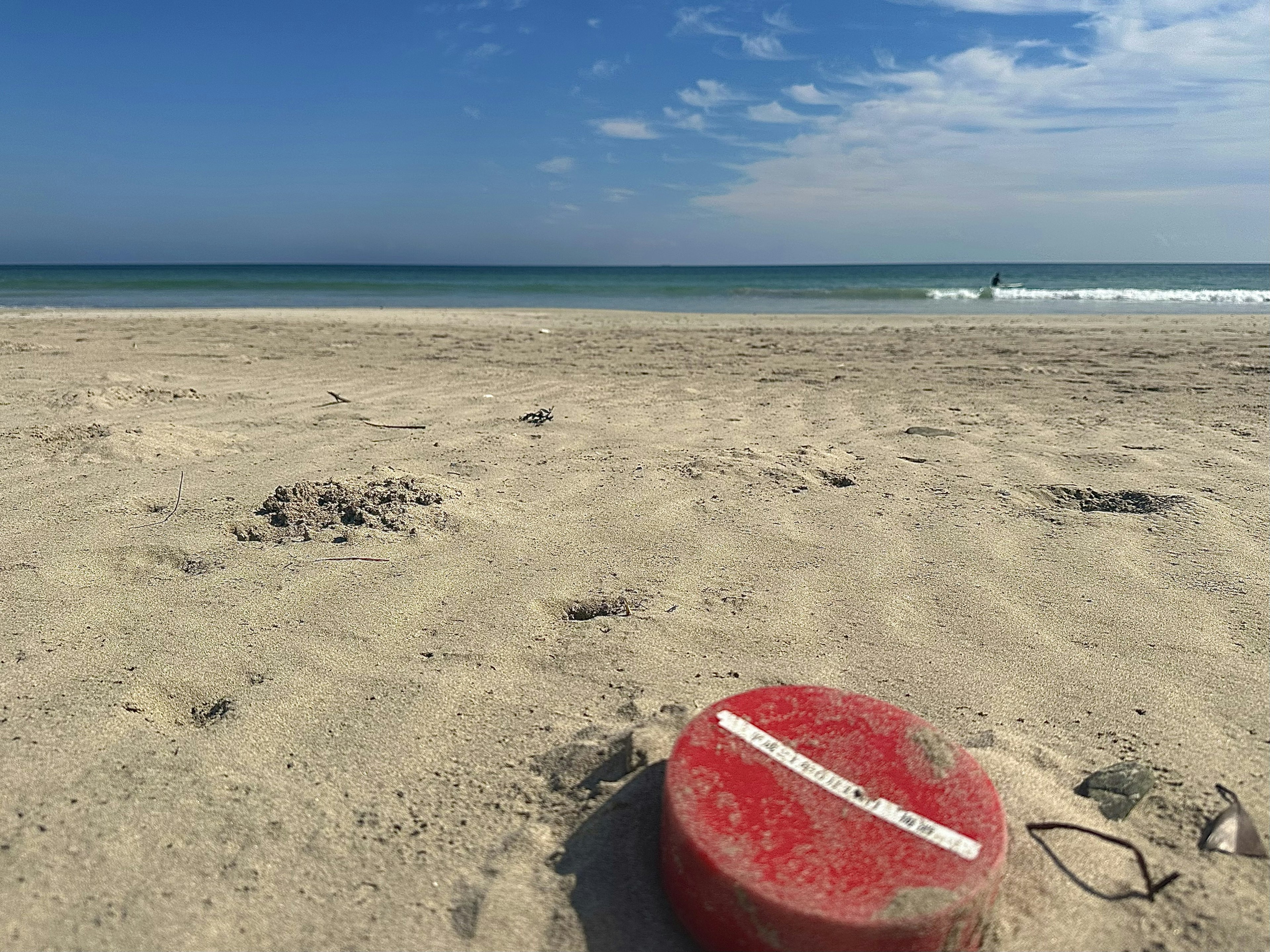 A red buoy on the sandy beach with a beautiful ocean view