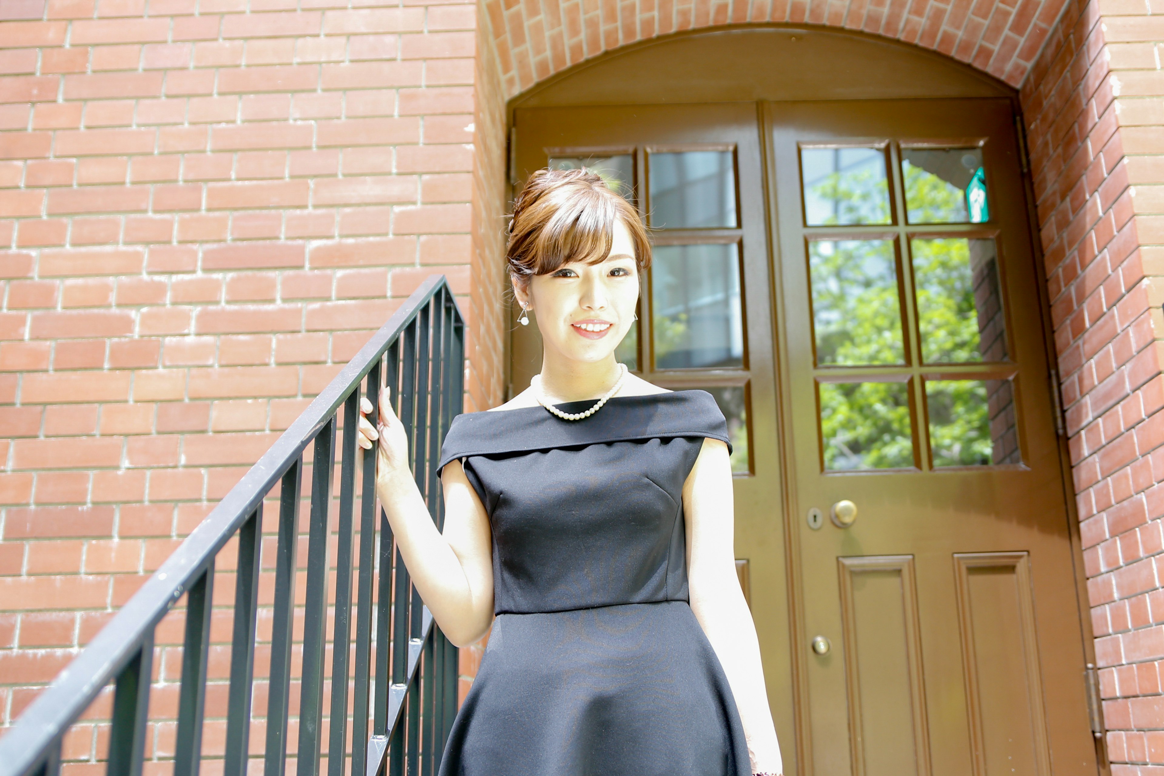 Woman in a black dress standing on stairs