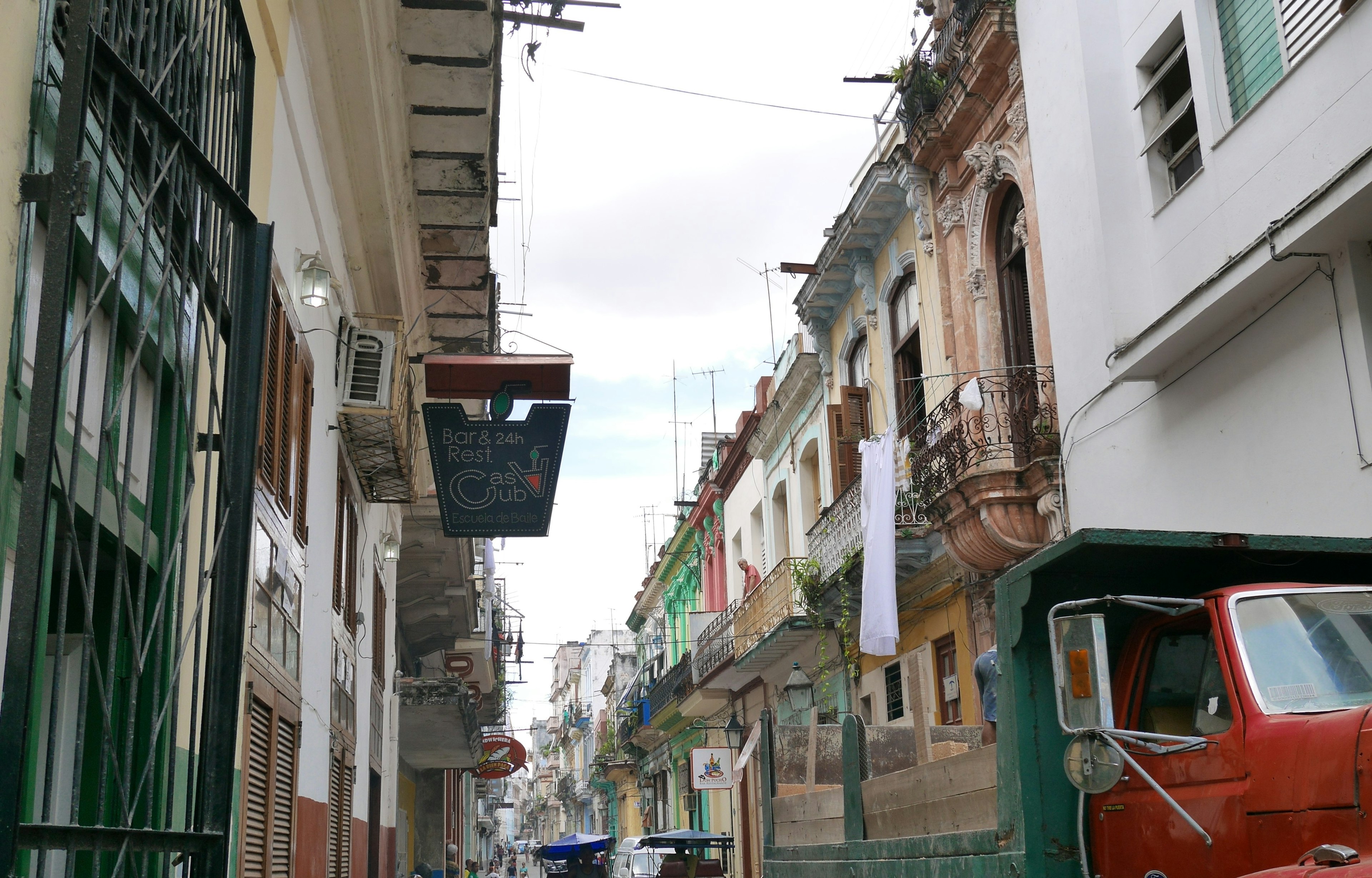 Street view featuring old buildings and a red vehicle