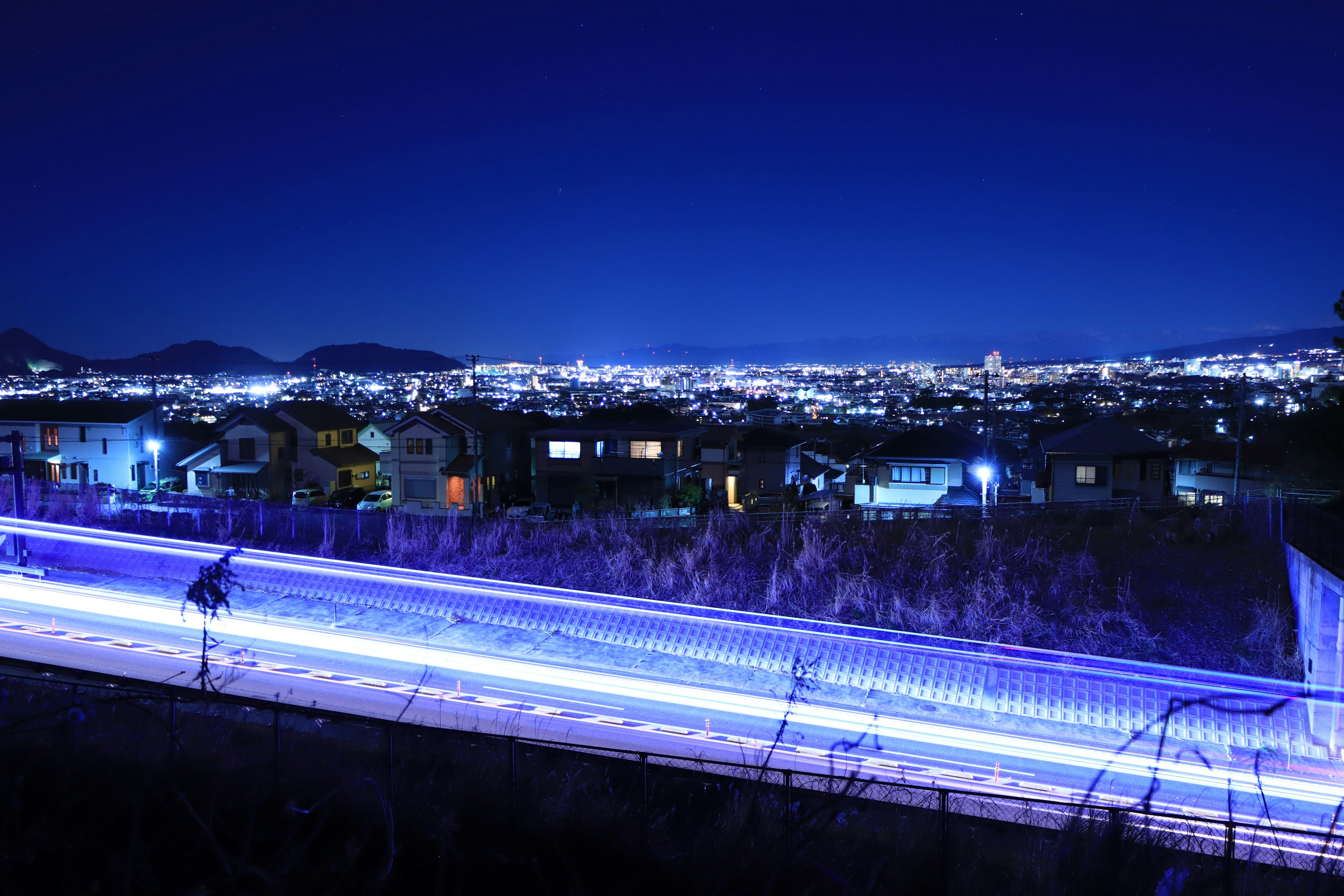 Magnifique panorama urbain nocturne avec des traînées de lumière bleue