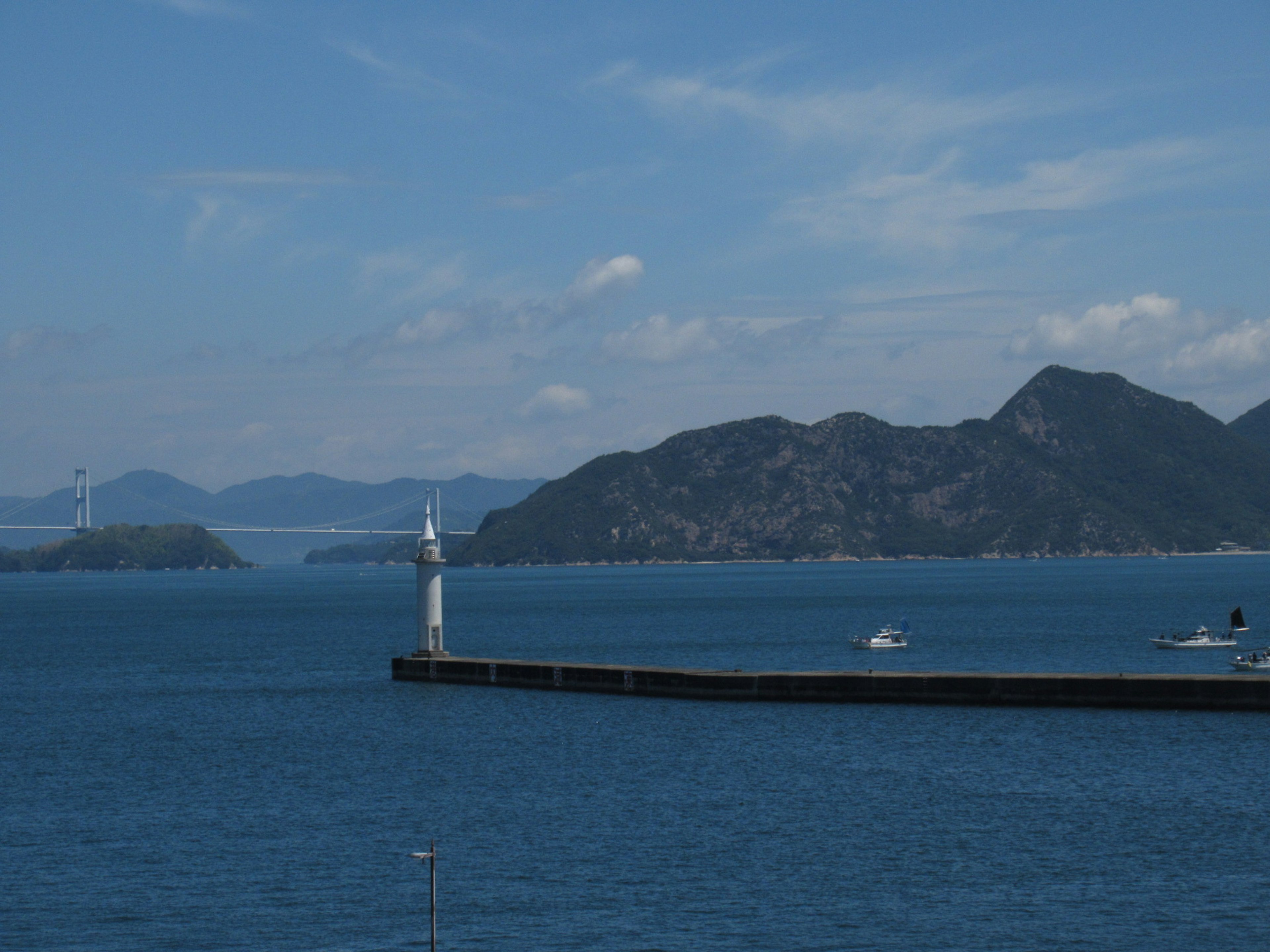 Vista escénica de un puerto con un faro y aguas azules