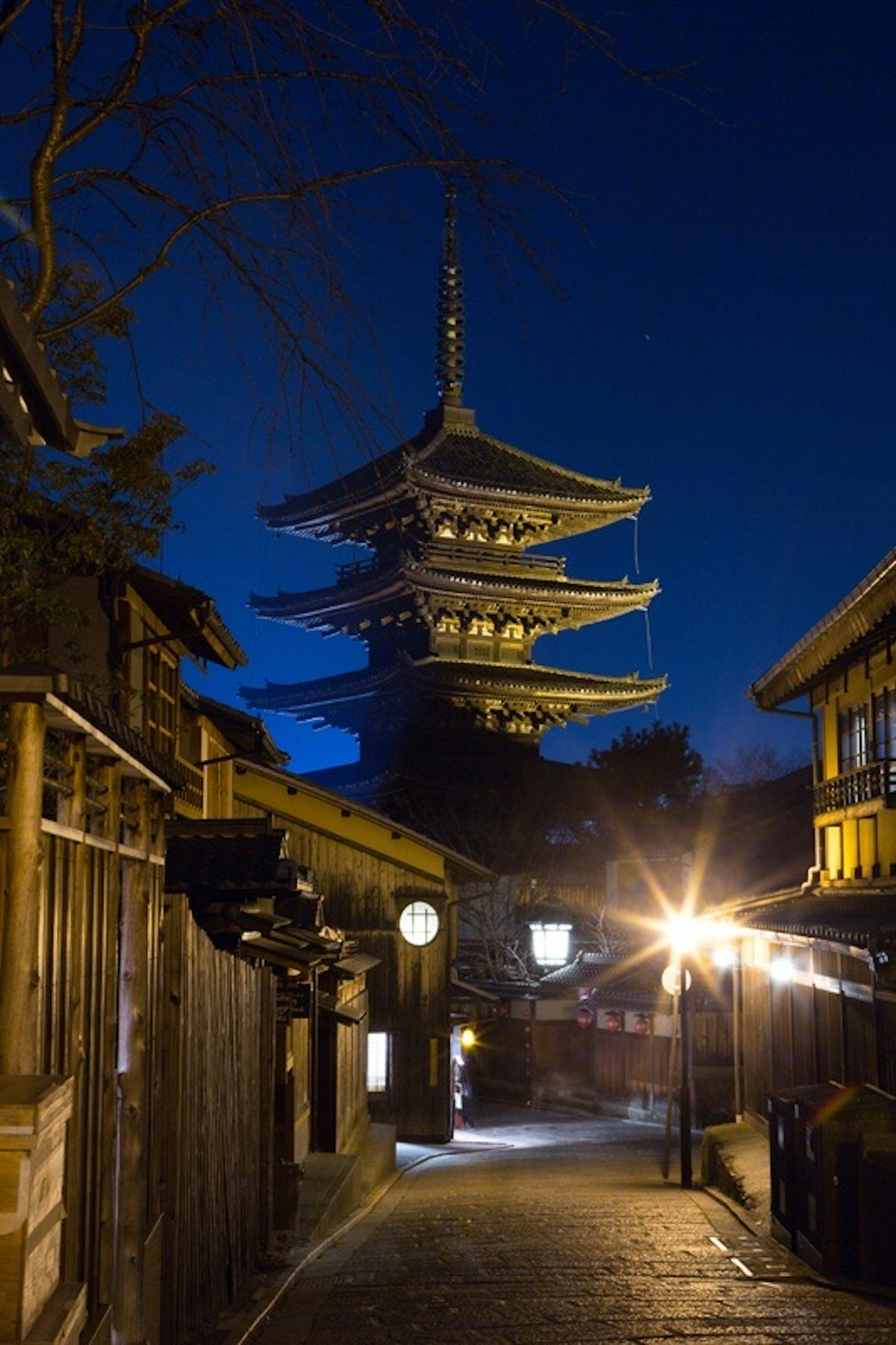 Vue nocturne d'une pagode entourée de bâtiments traditionnels