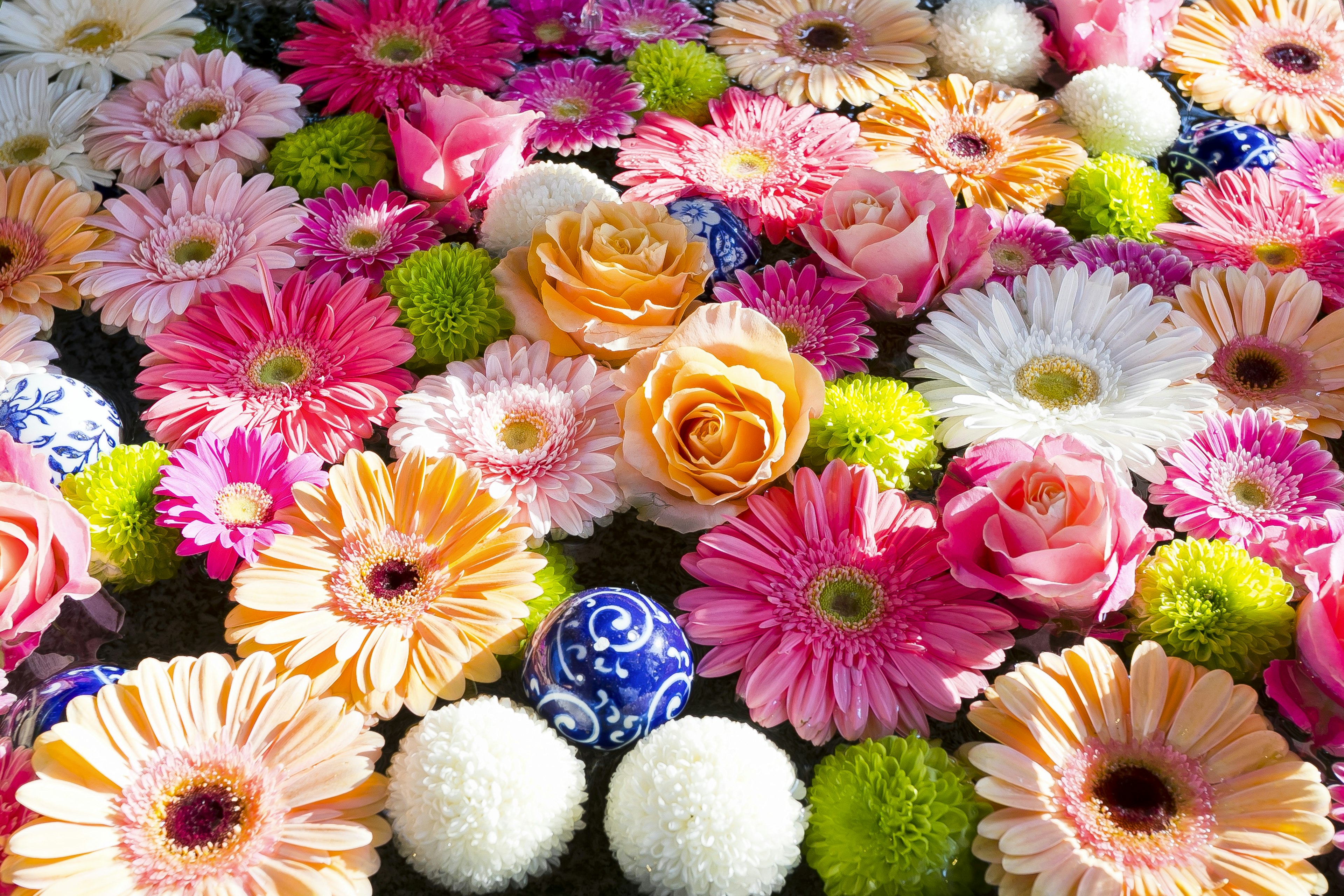 Ein lebhaftes Arrangement aus verschiedenen bunten Blumen, darunter Rosen und Gerbera