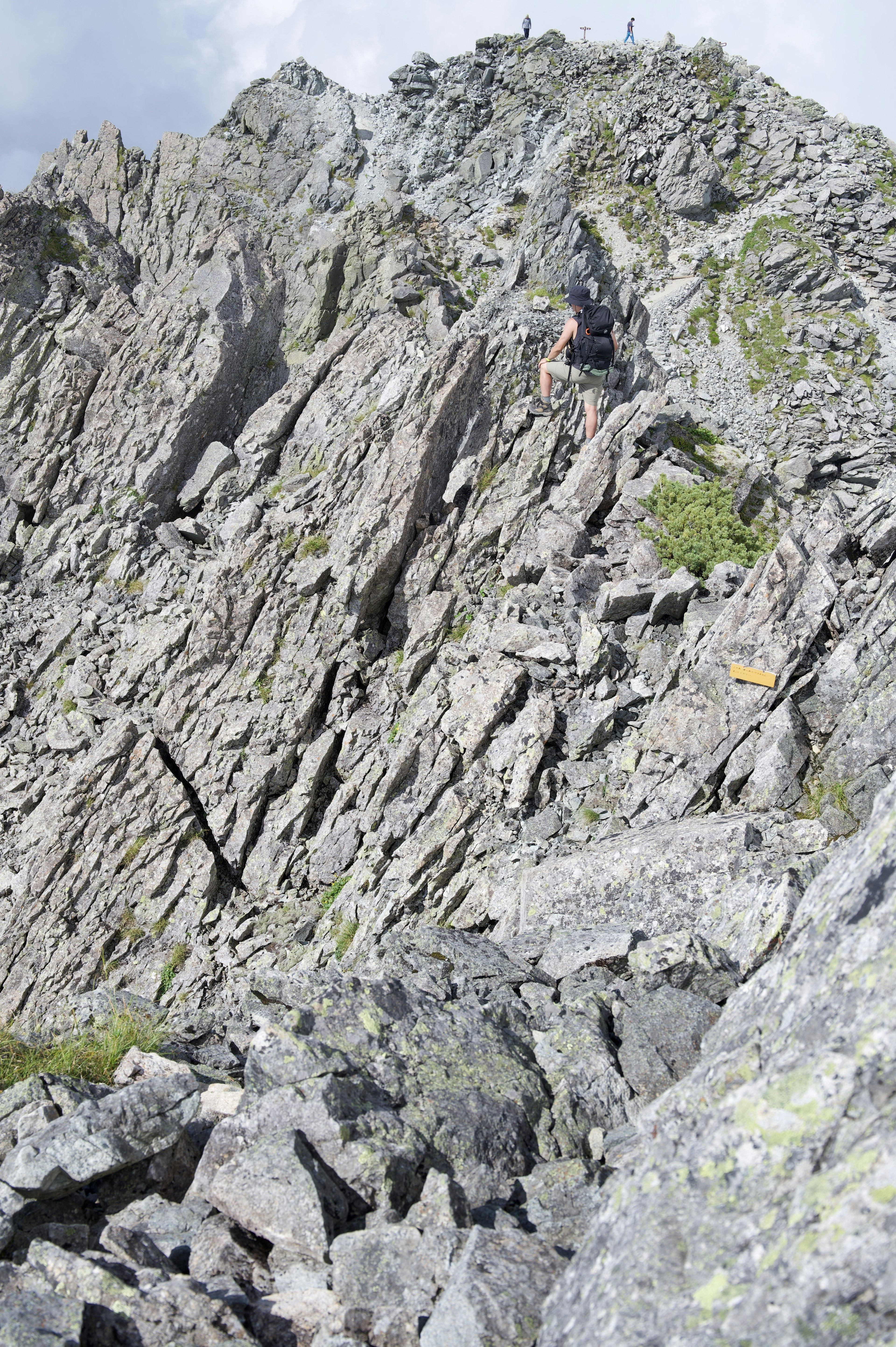 Bergsteiger, die einen steilen, felsigen Hang hinaufsteigen