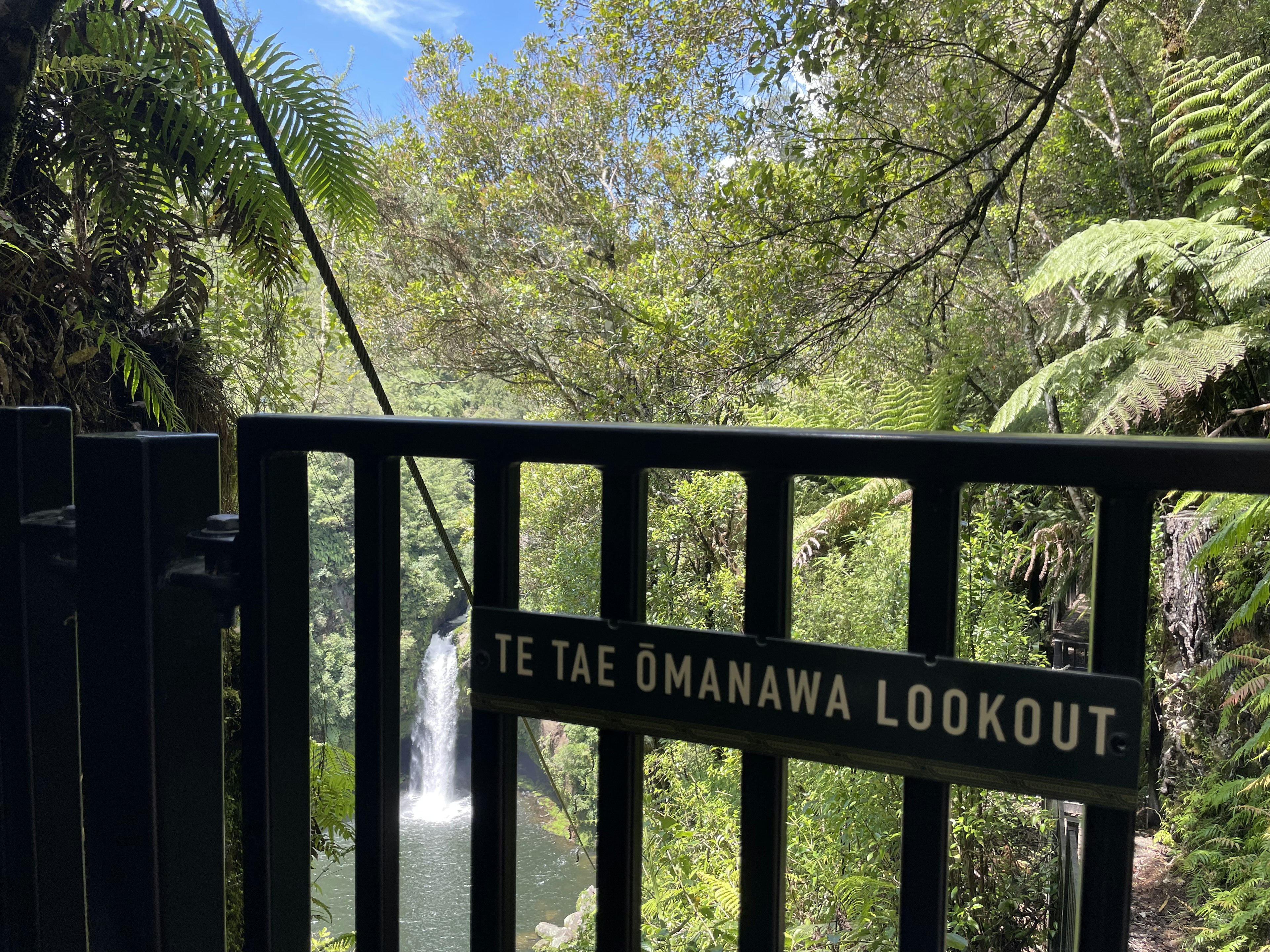 Gerbang Te Tae Ōmanawa Lookout dengan latar belakang vegetasi yang subur