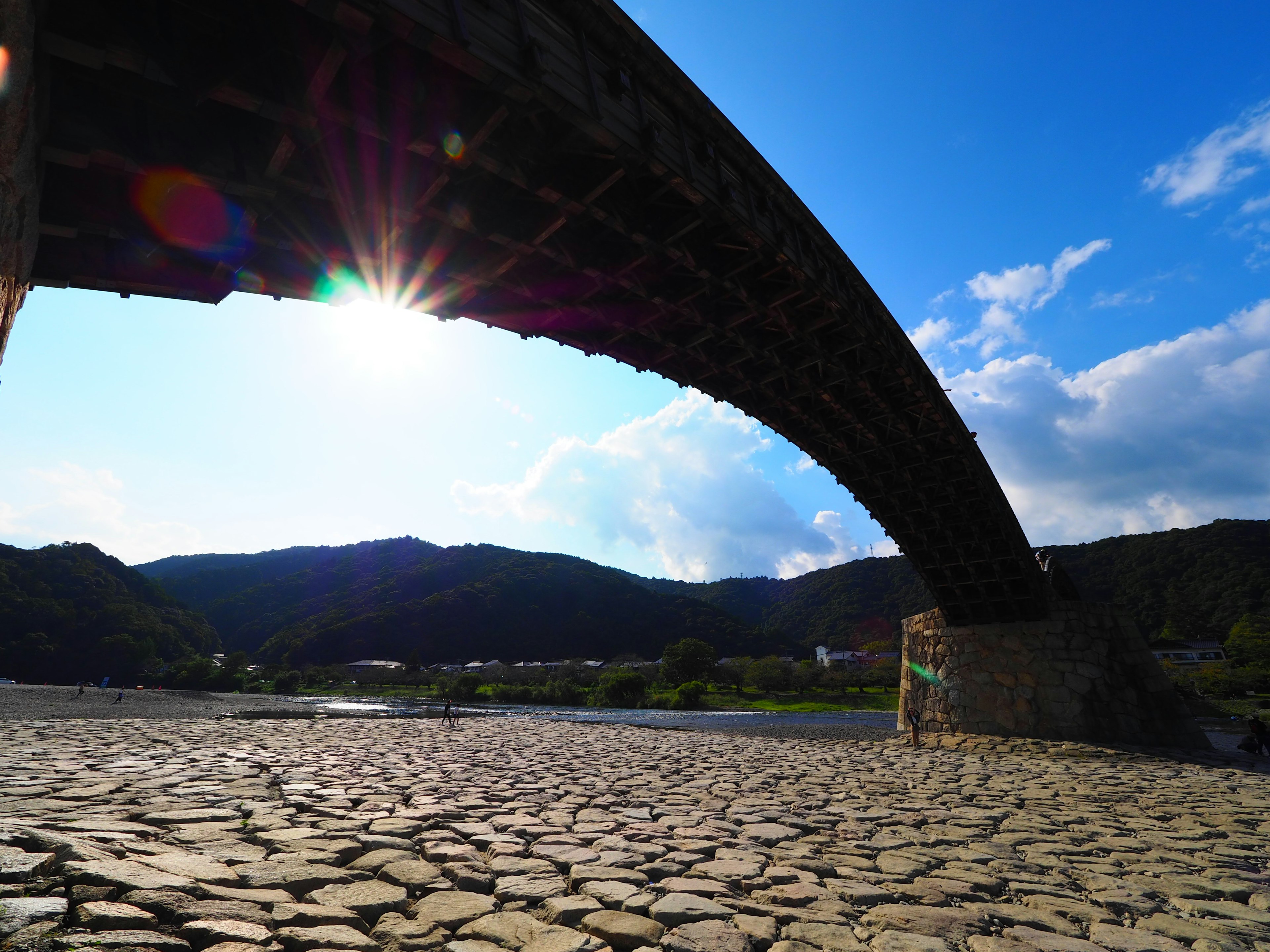 Vista desde debajo de un hermoso puente en arco con montañas circundantes