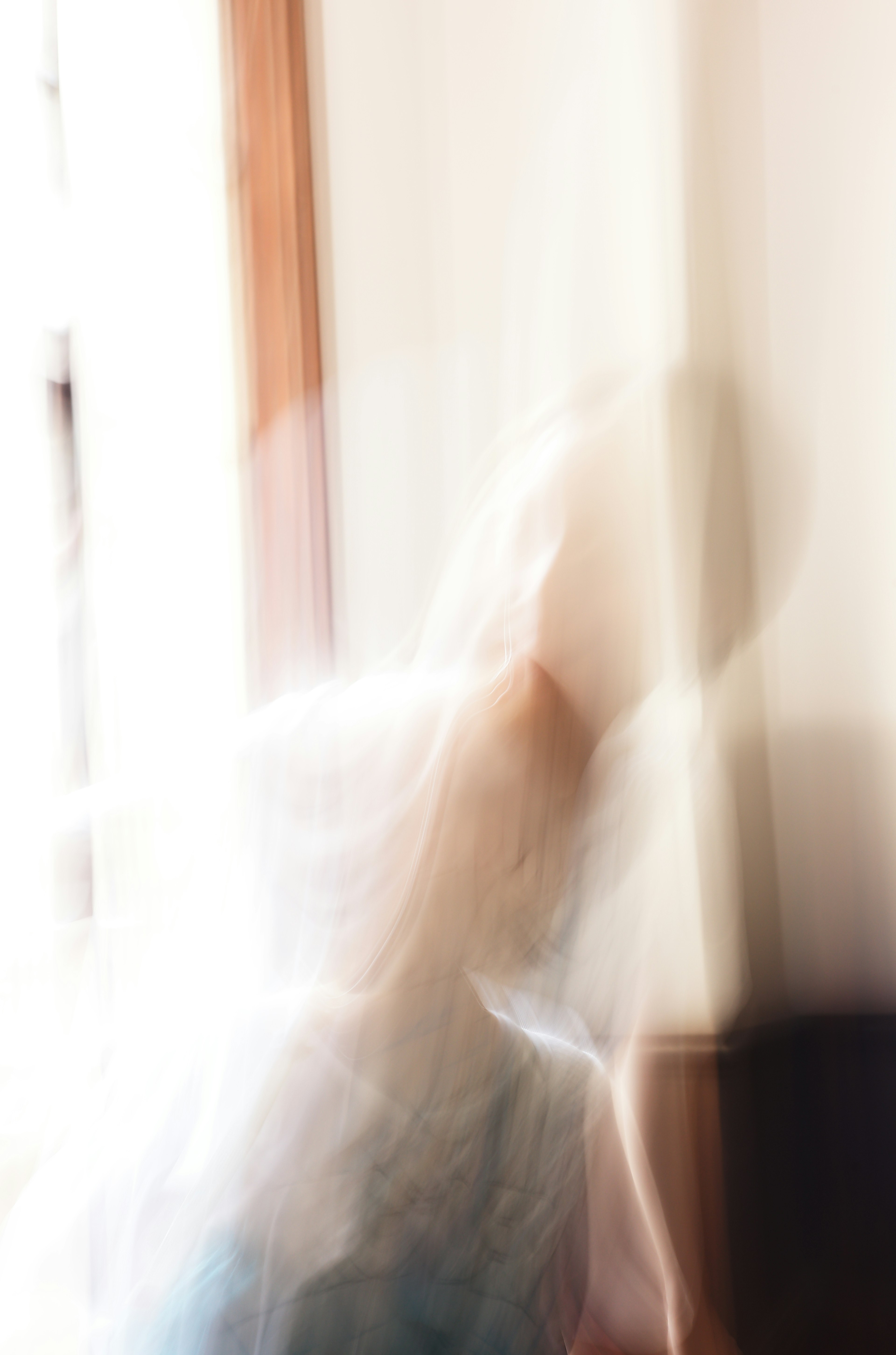 Blurred figure in motion near a window