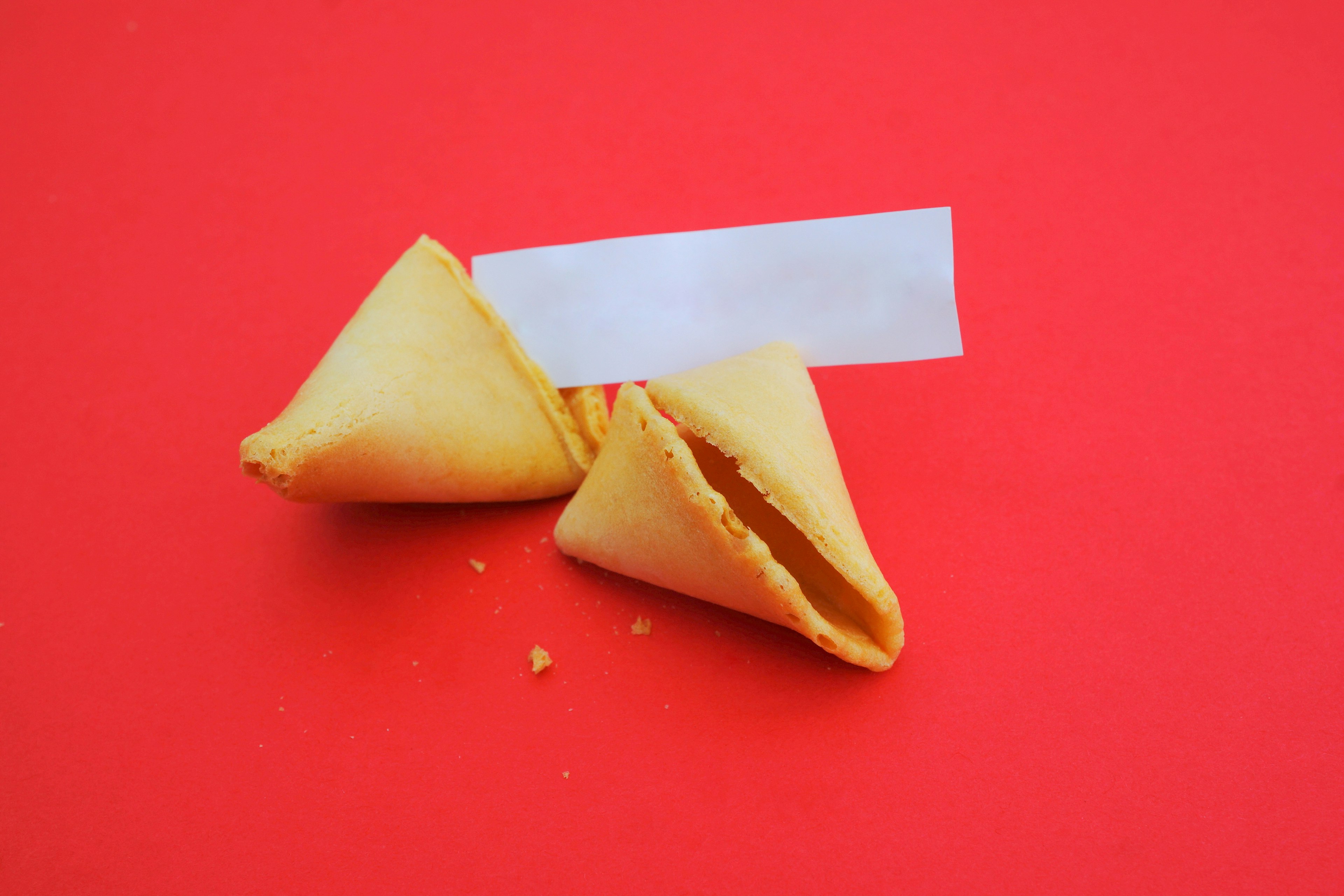 Two opened fortune cookies on a red background