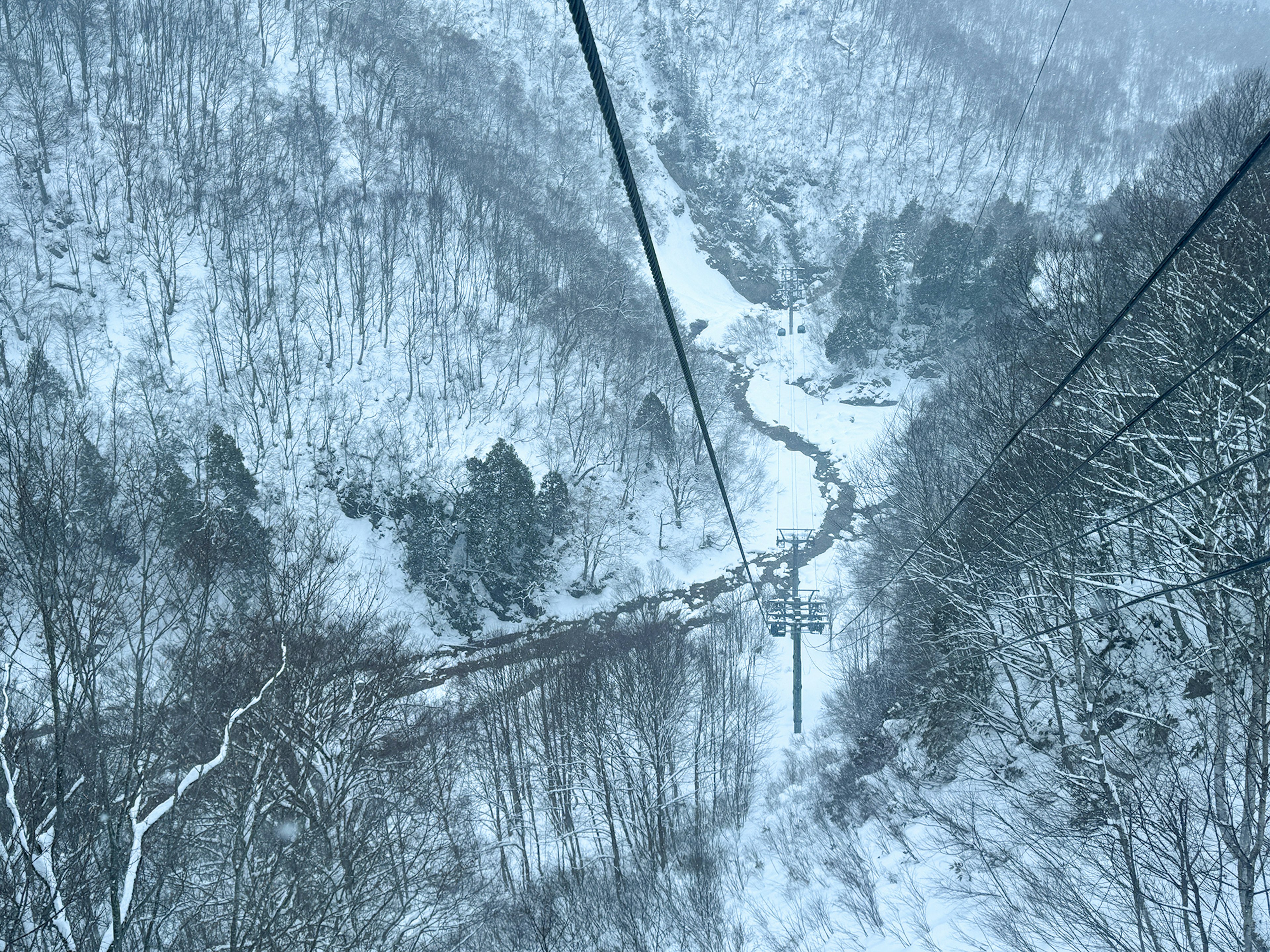 Snow-covered mountain landscape with a cable car view