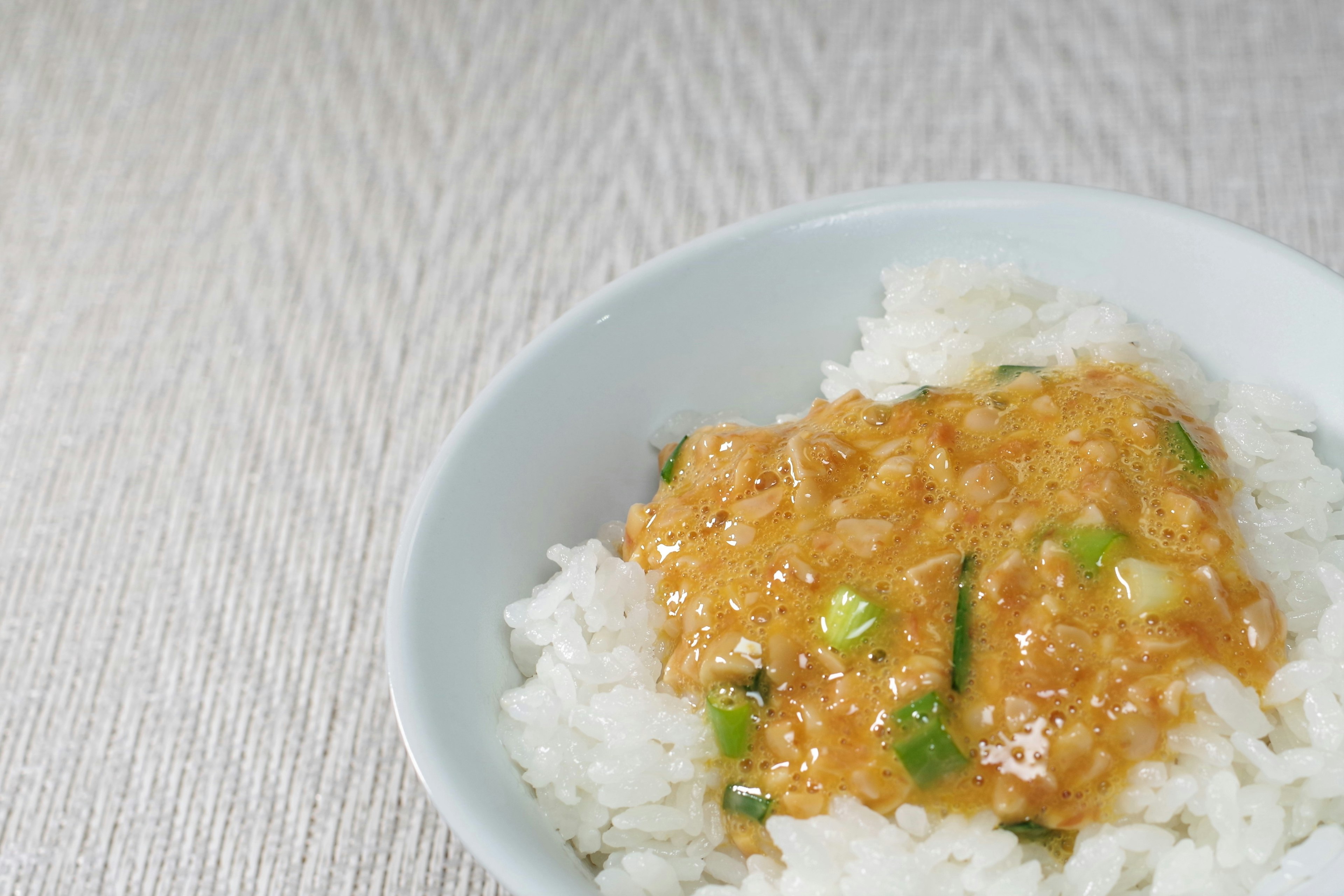 Riz blanc surmonté d'une sauce orange et d'oignons verts