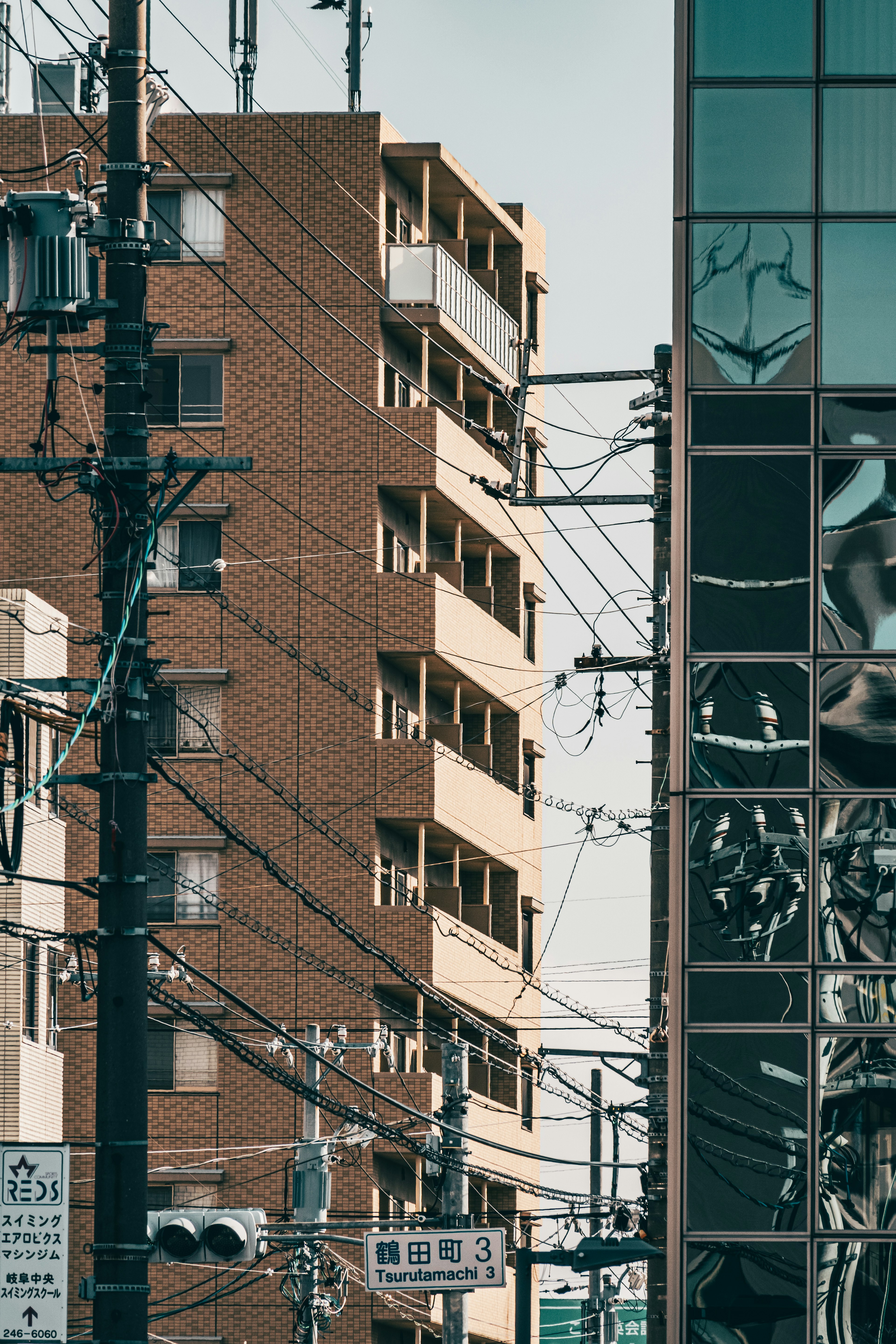 茶色の建物とガラス張りのビルが並ぶ街角の風景