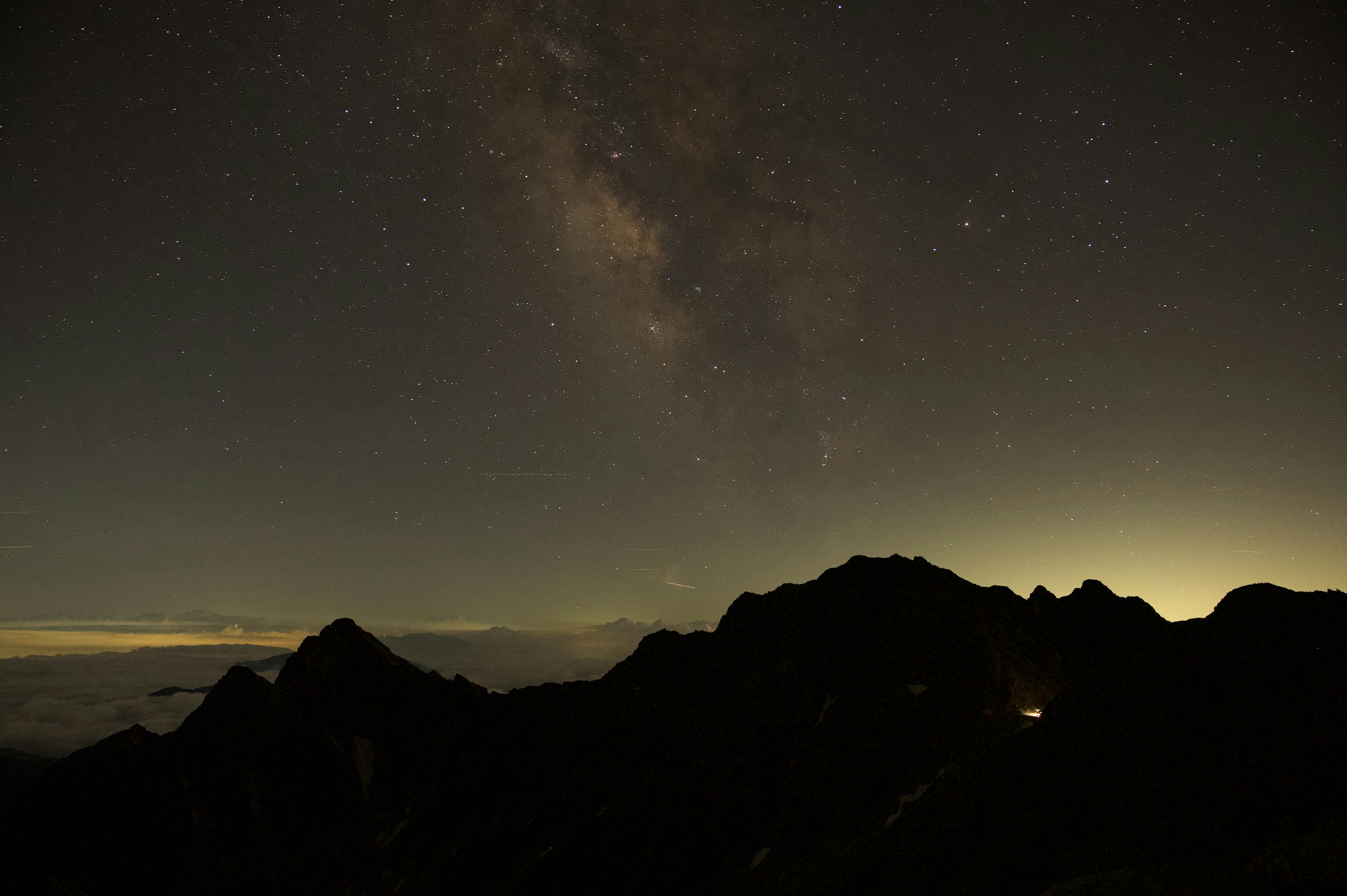 Ciel nocturne avec des étoiles et silhouette de montagnes