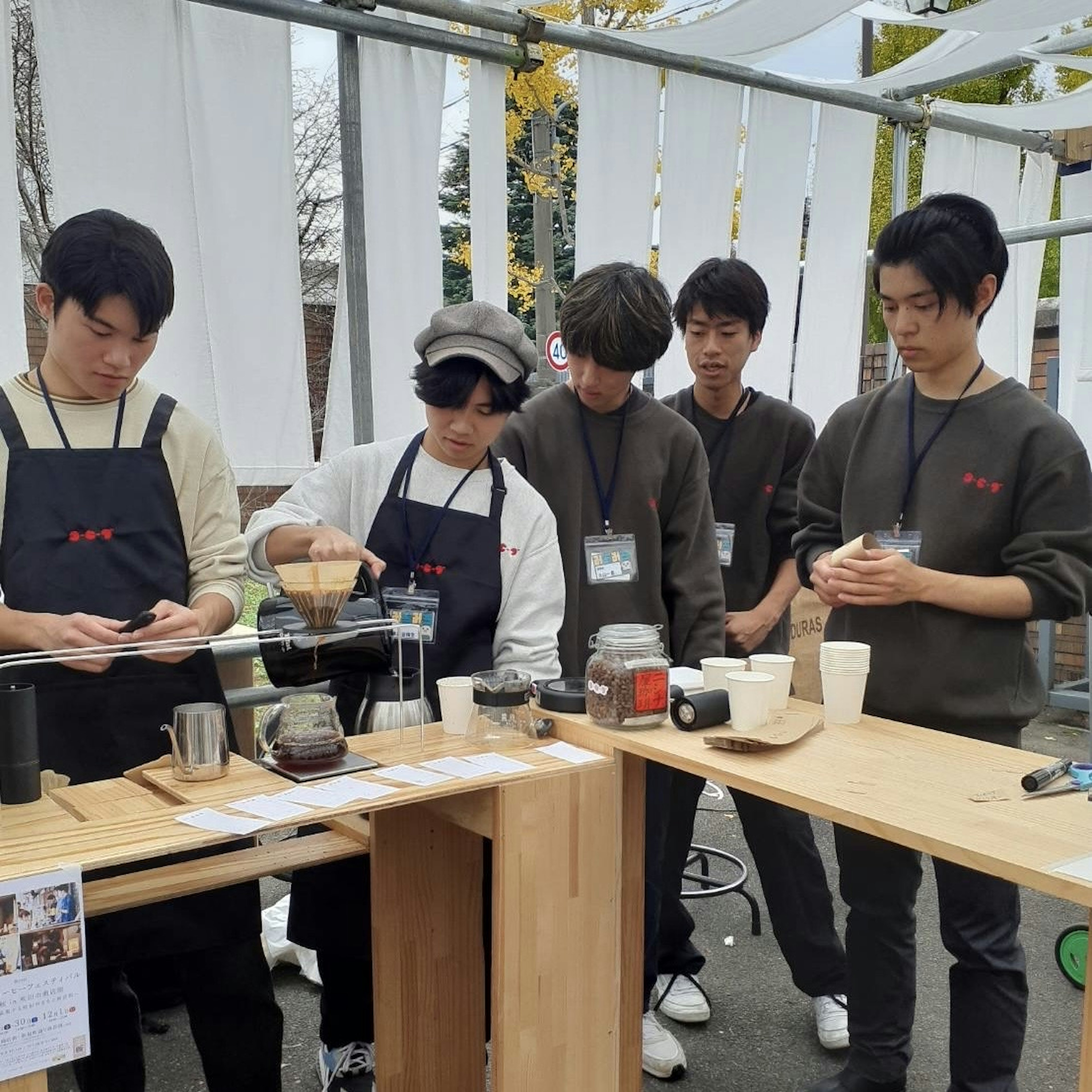 Jeunes hommes préparant du café dans un café en plein air