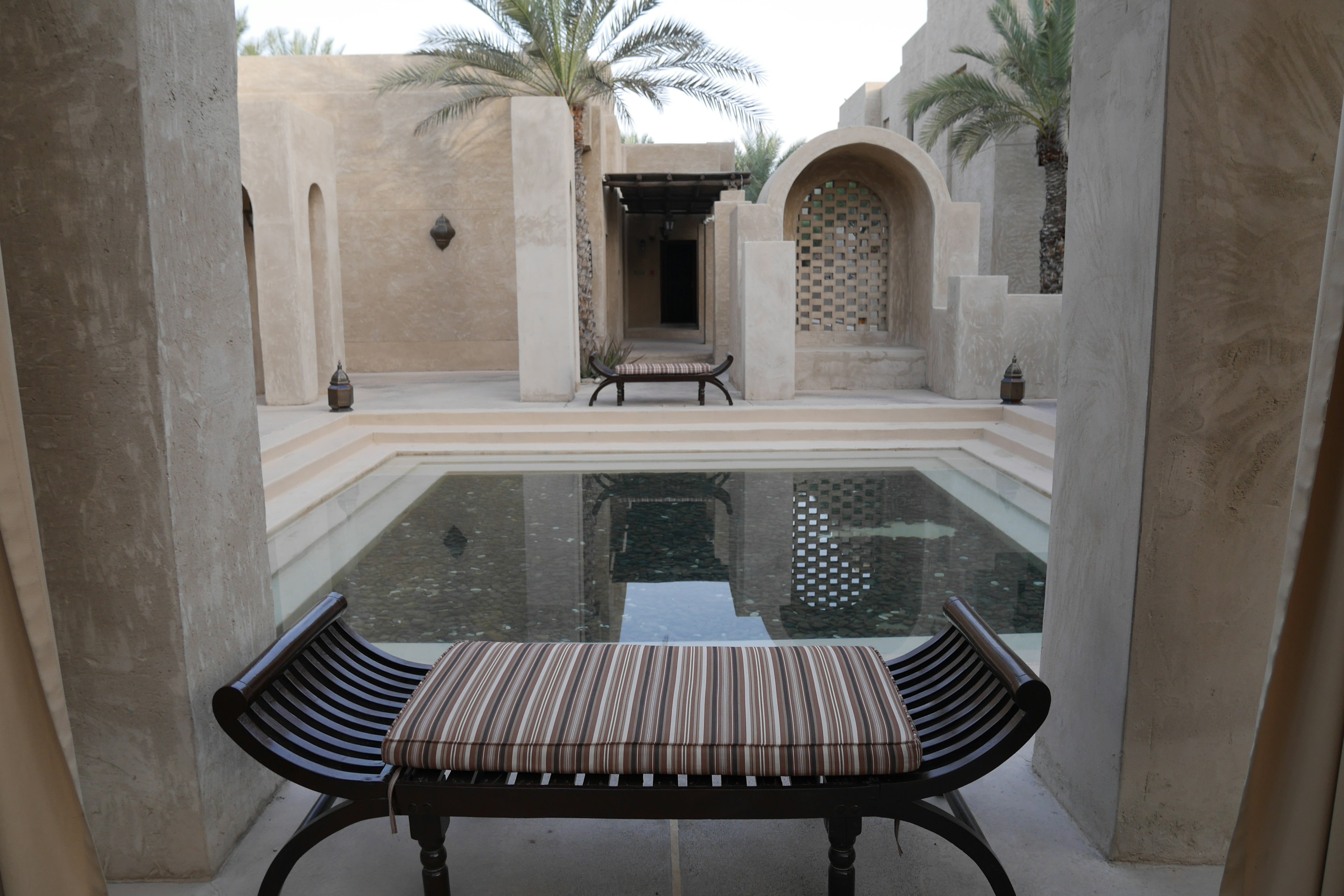 Vista di un cortile con una piscina e una panchina