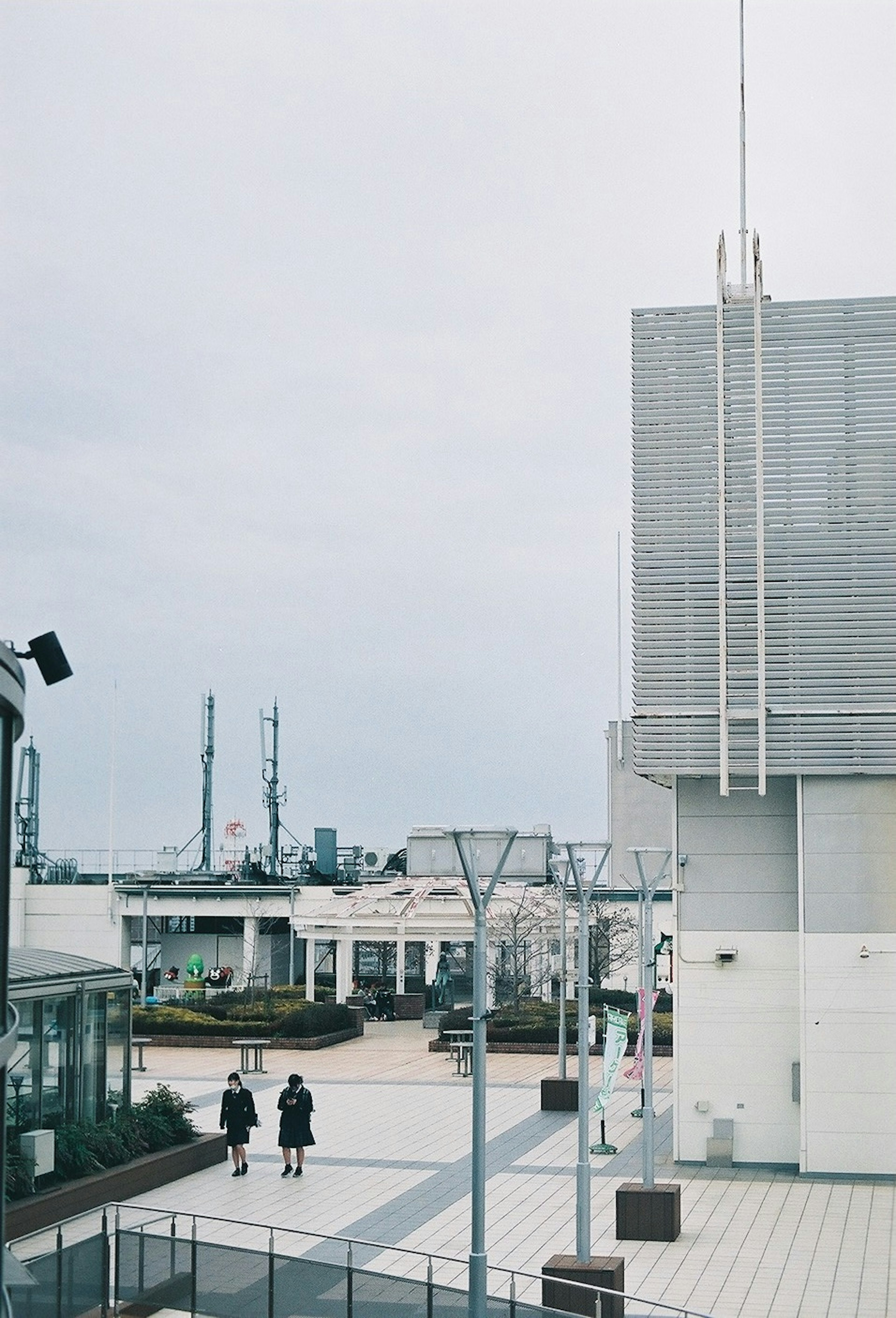 A cloudy day with two people walking in a nearby square