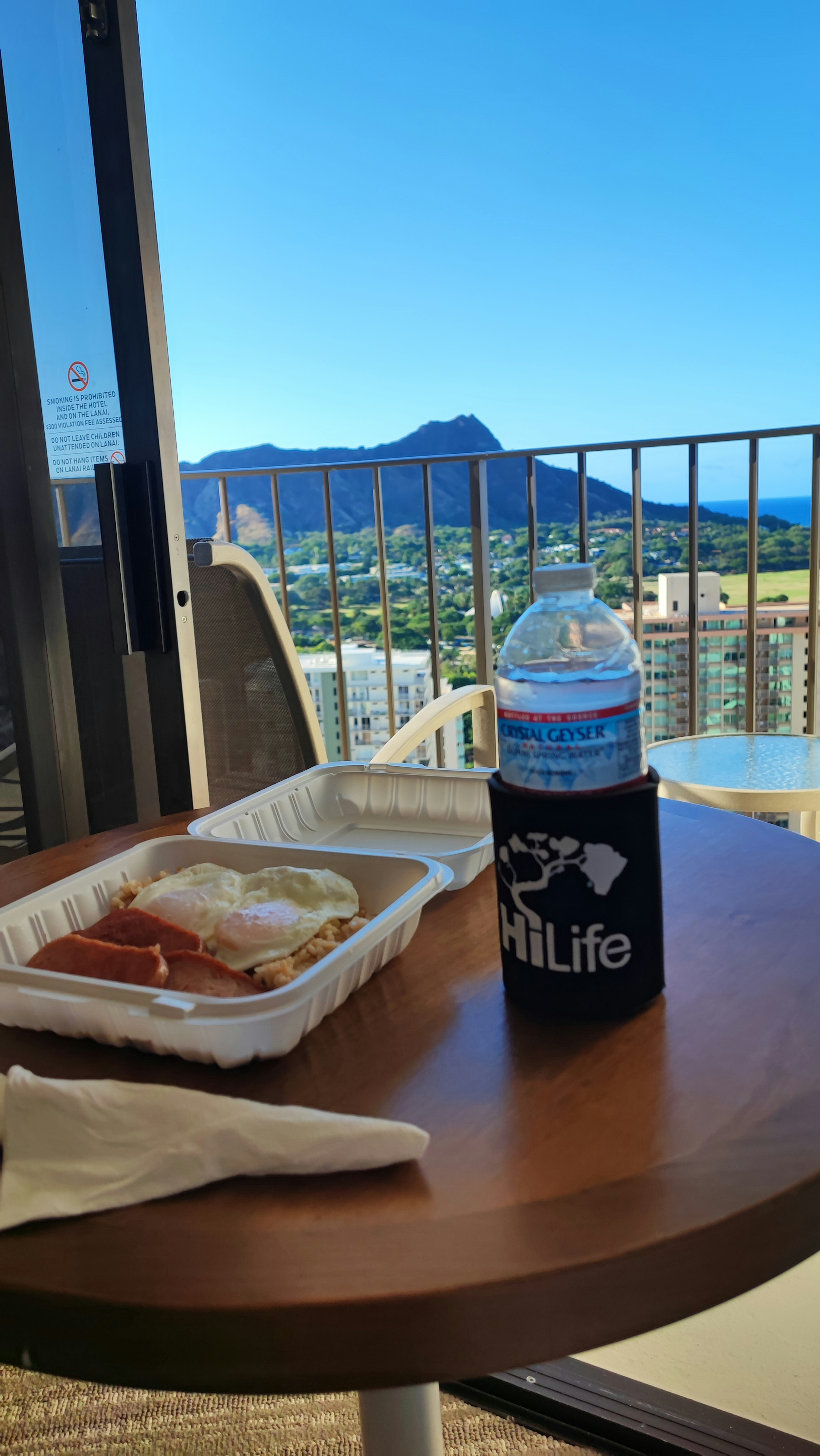 Repas et bouteille d'eau sur une table de balcon avec une vue magnifique sur la montagne en arrière-plan