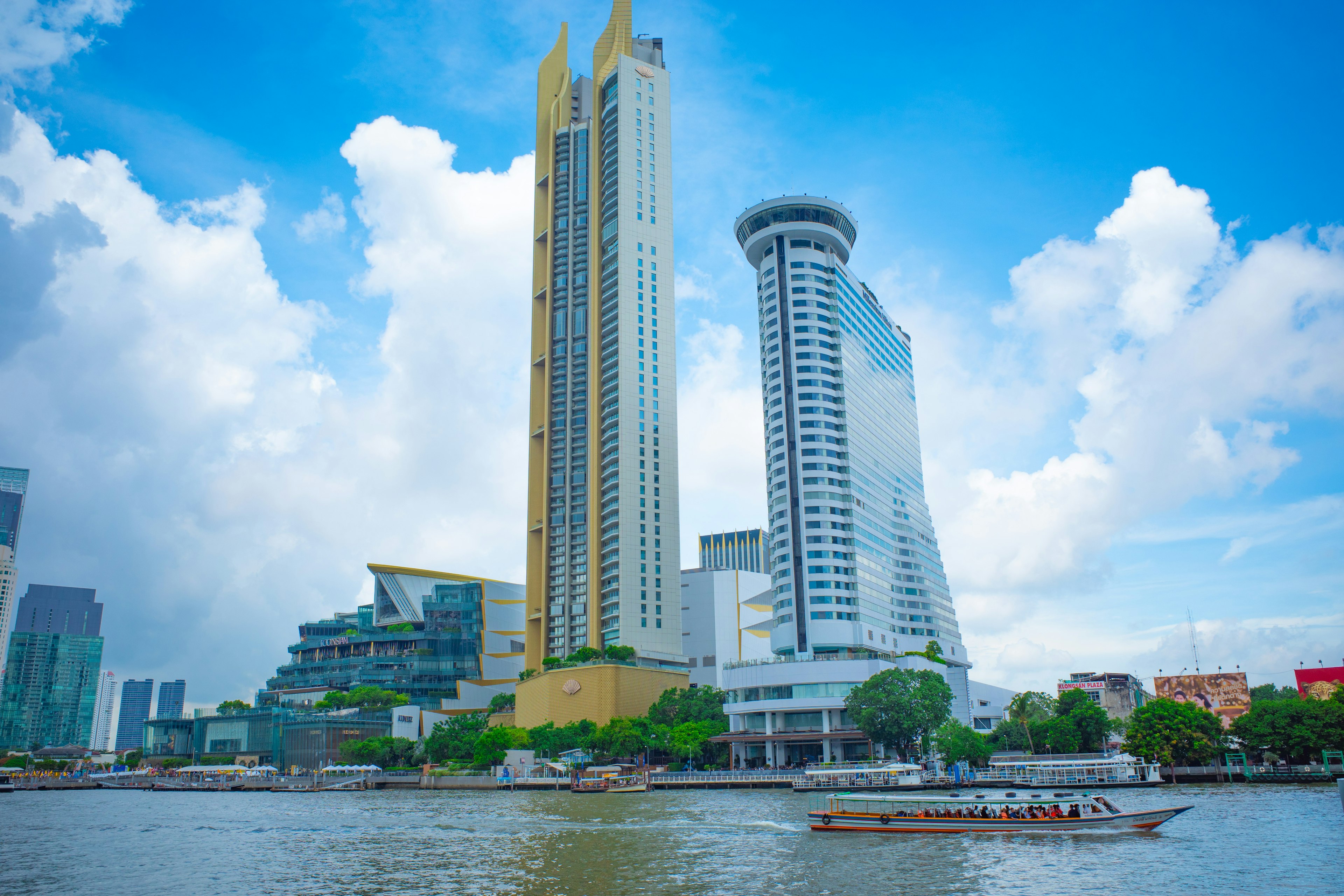 Skyline of Bangkok along Chao Phraya River featuring modern skyscrapers and blue sky