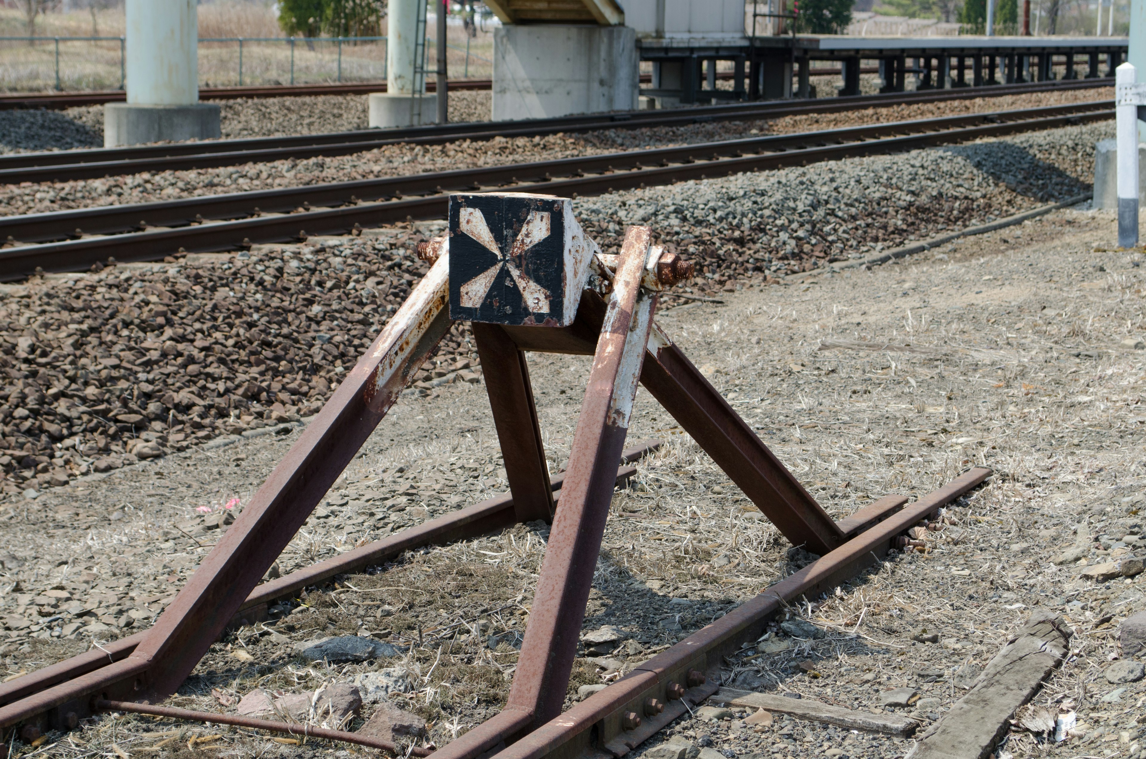 鉄道のレールを支える古い信号機とその周囲の風景