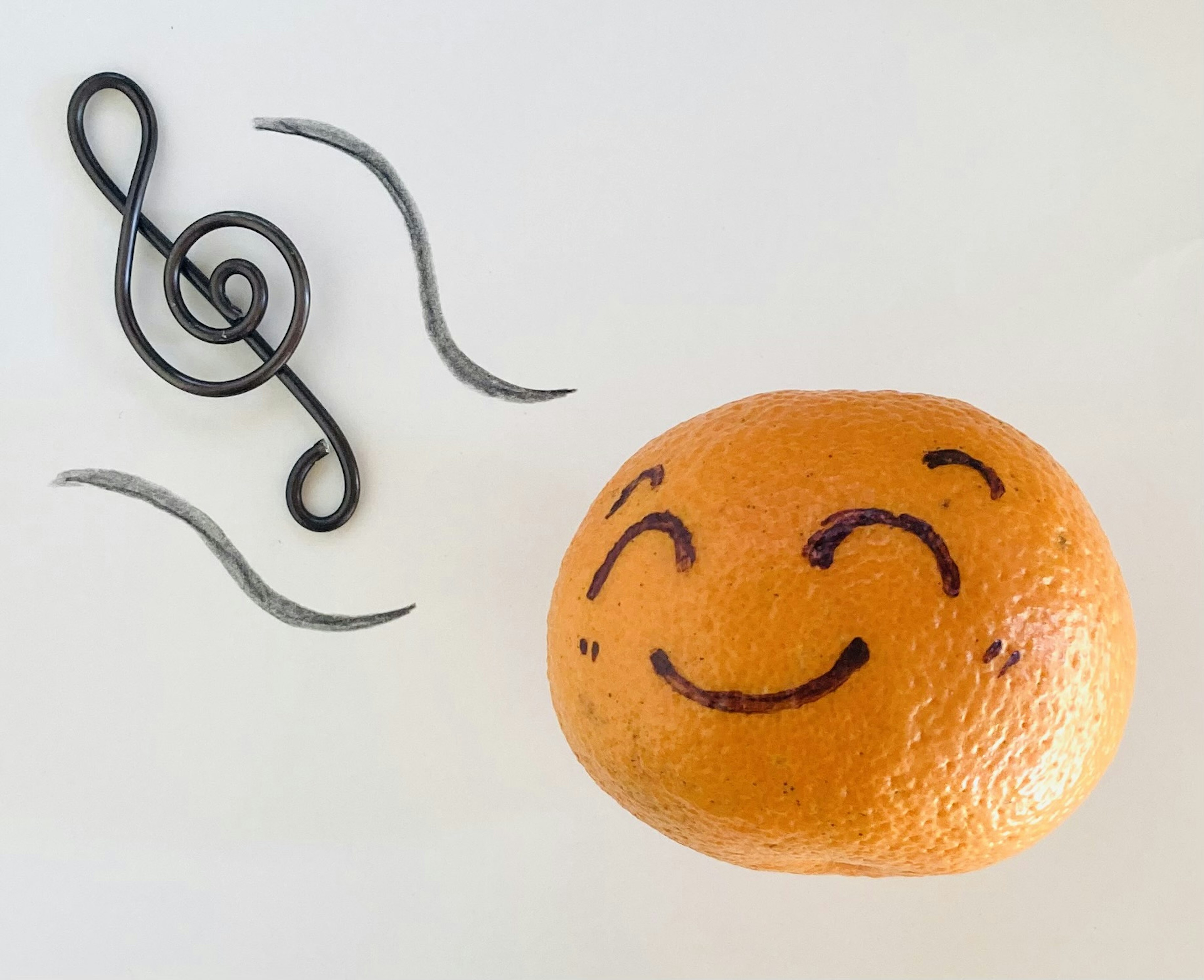 Orange souriante avec un visage dessiné et des notes de musique