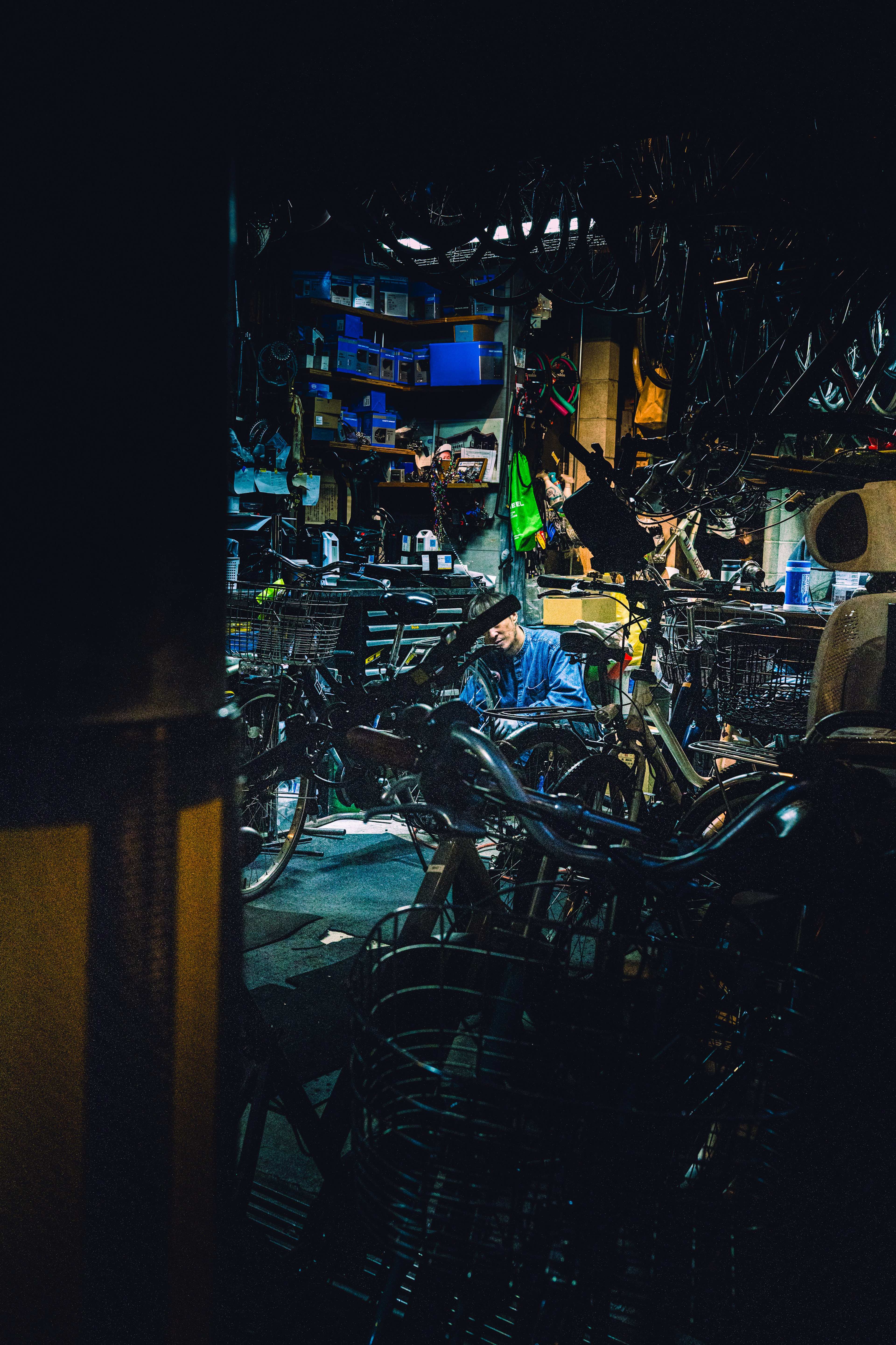 A bicycle repair shop with a person working among numerous bicycles