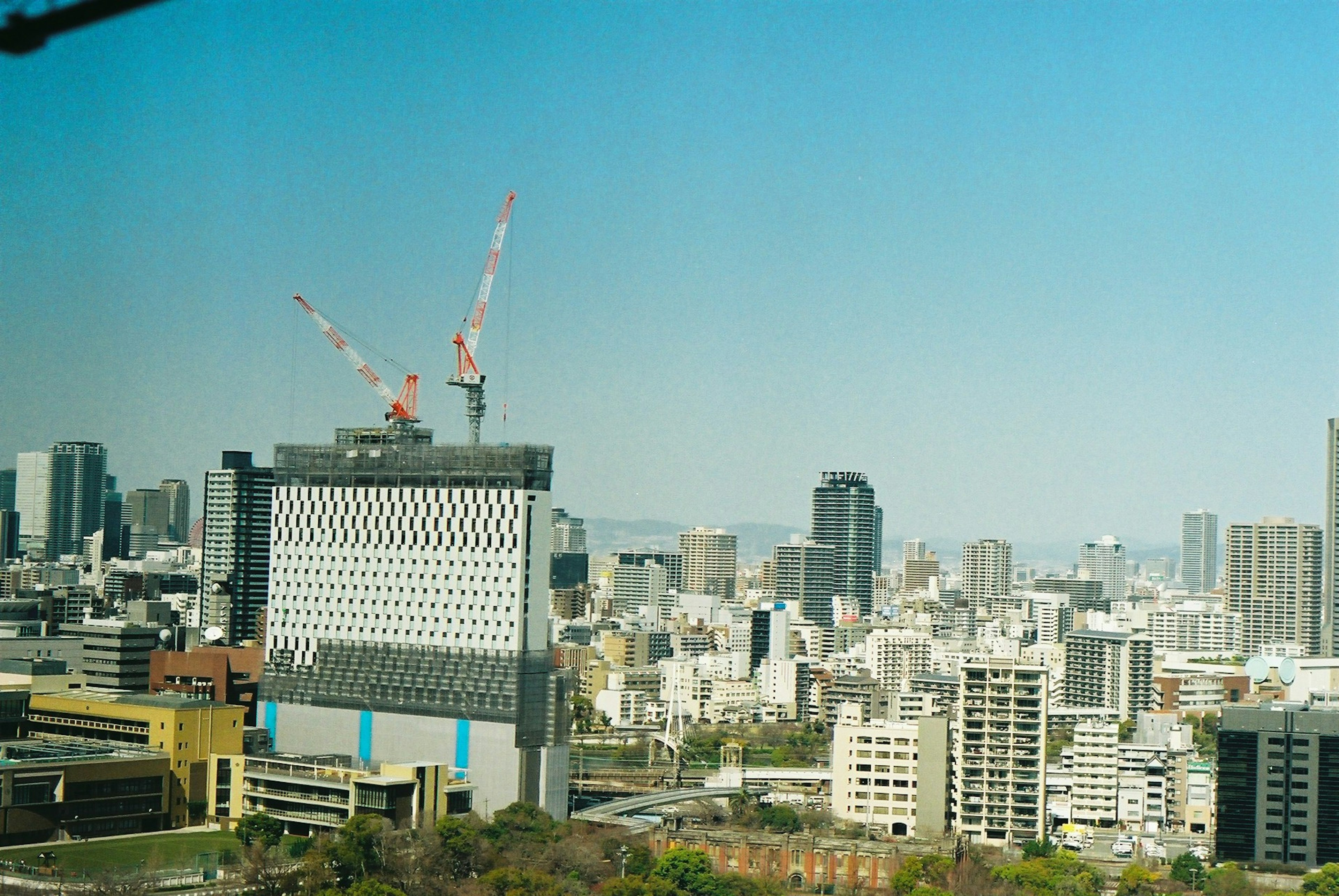 Paysage urbain sous un ciel bleu avec des grues de construction et des bâtiments