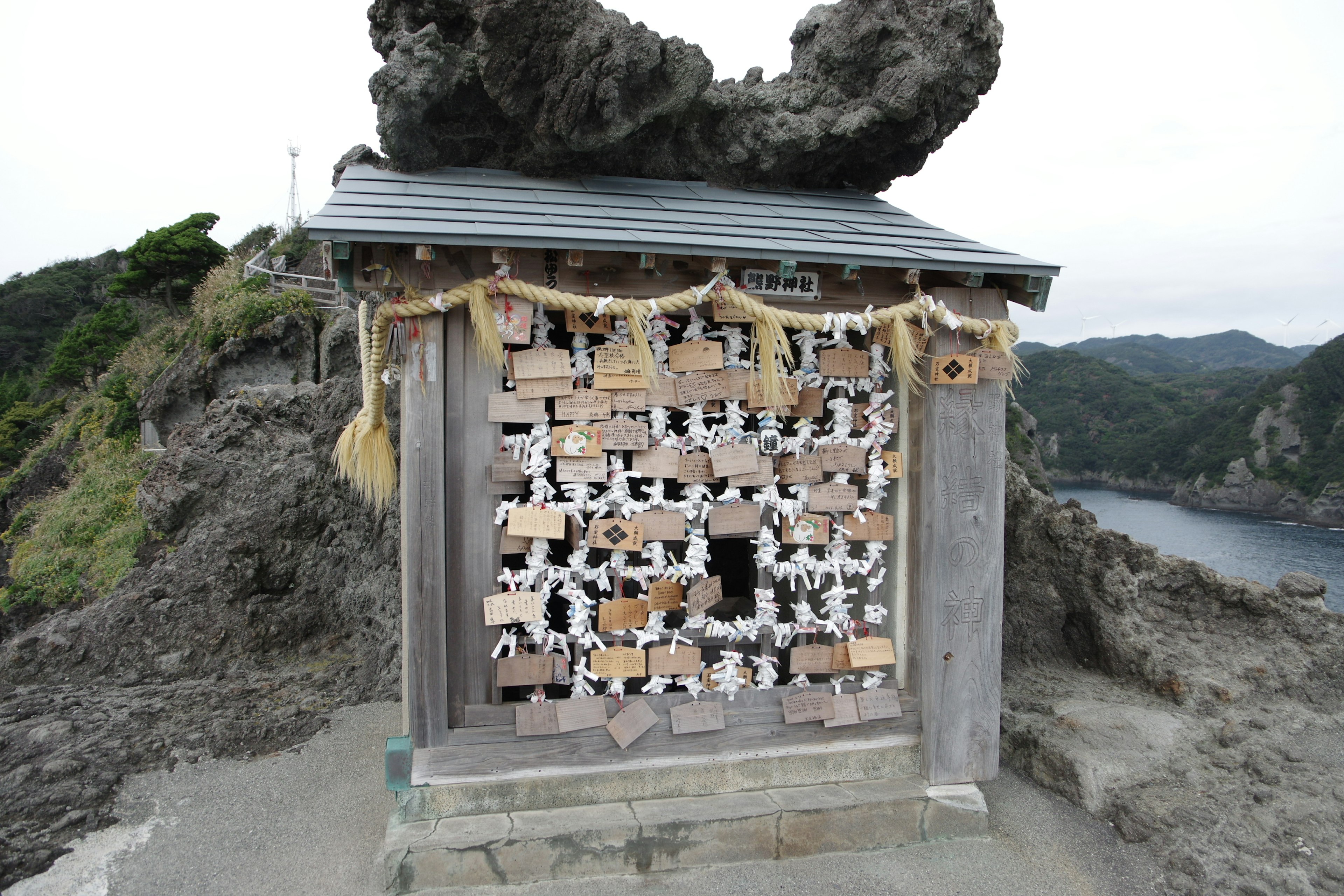 岩の上にある神社のような建物と周囲の自然