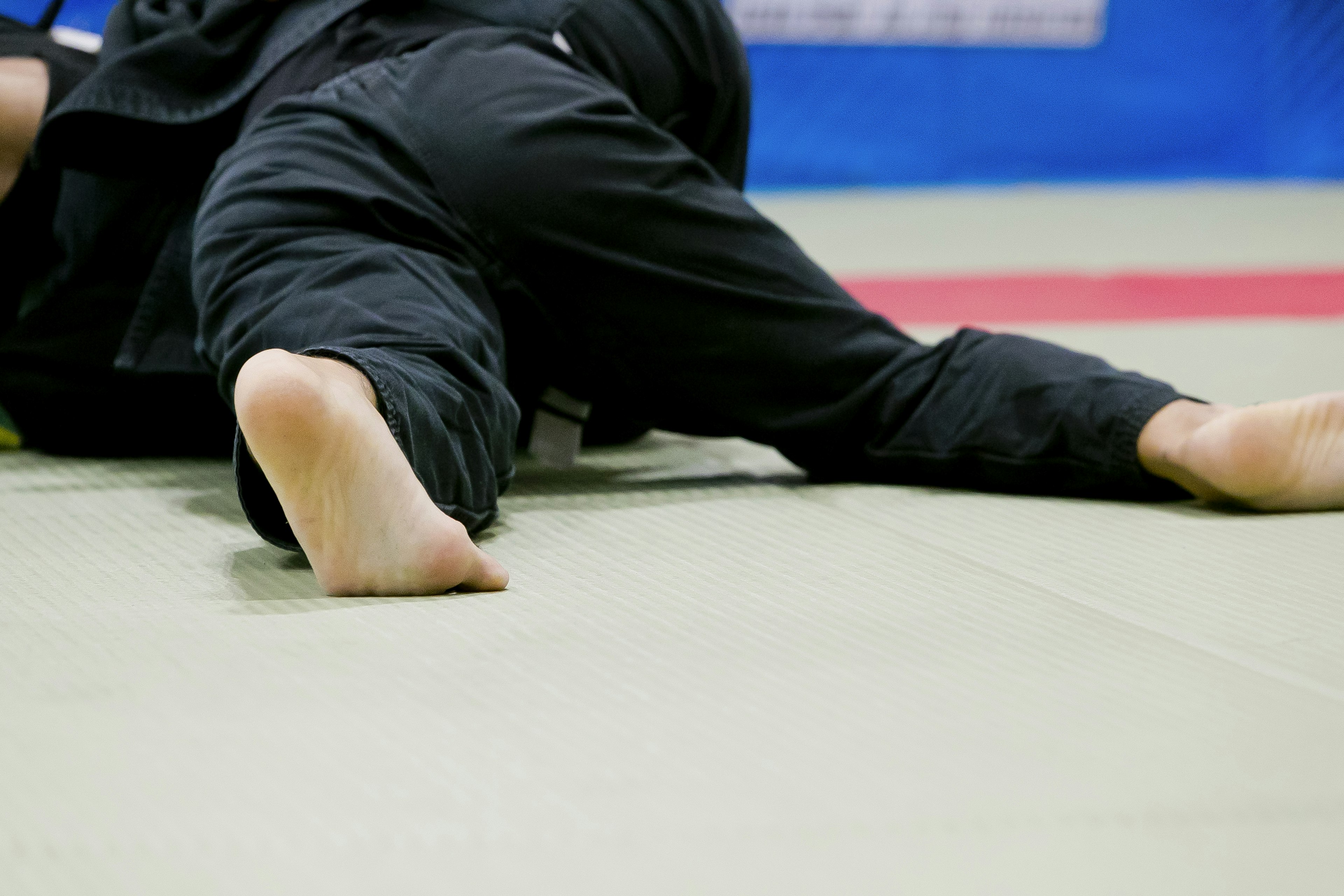 Nahaufnahme der Füße von zwei Athleten während des Judo-Trainings in einem Dojo