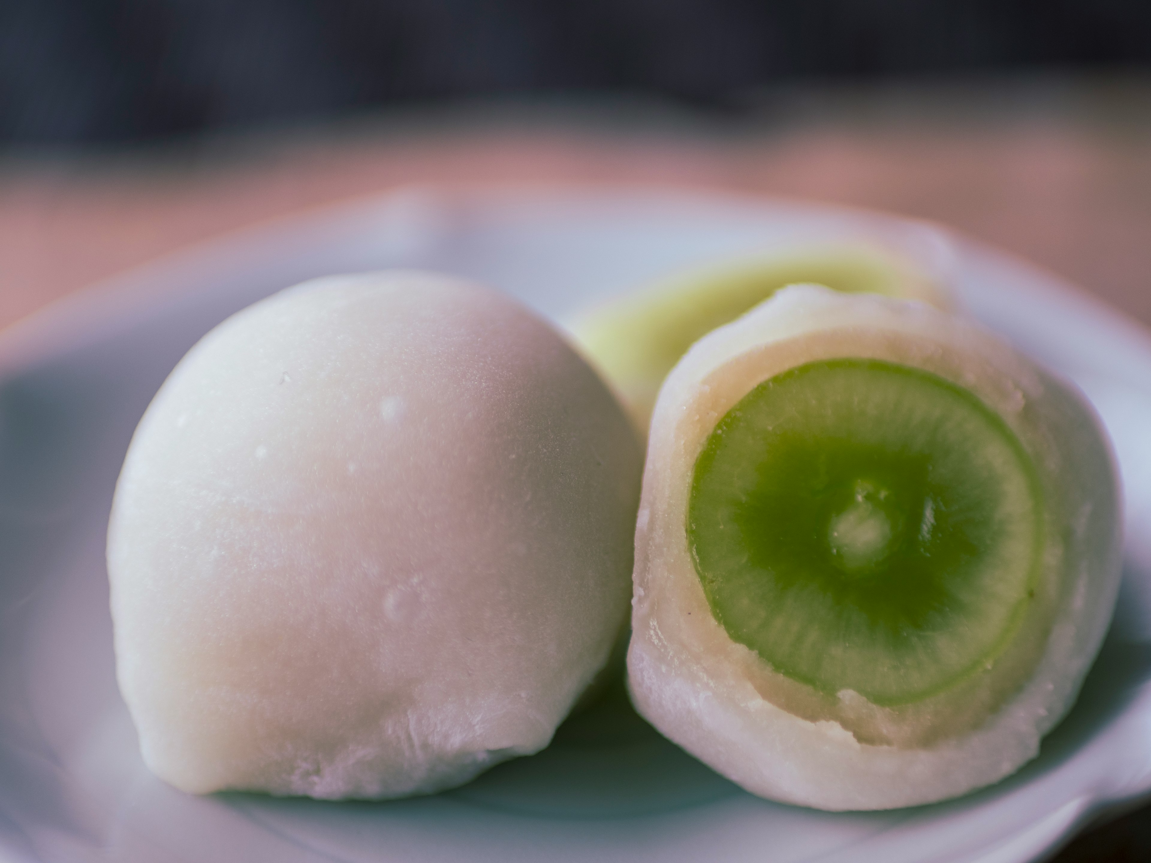 Postre japonés con relleno de fruta verde cortado por la mitad y entero