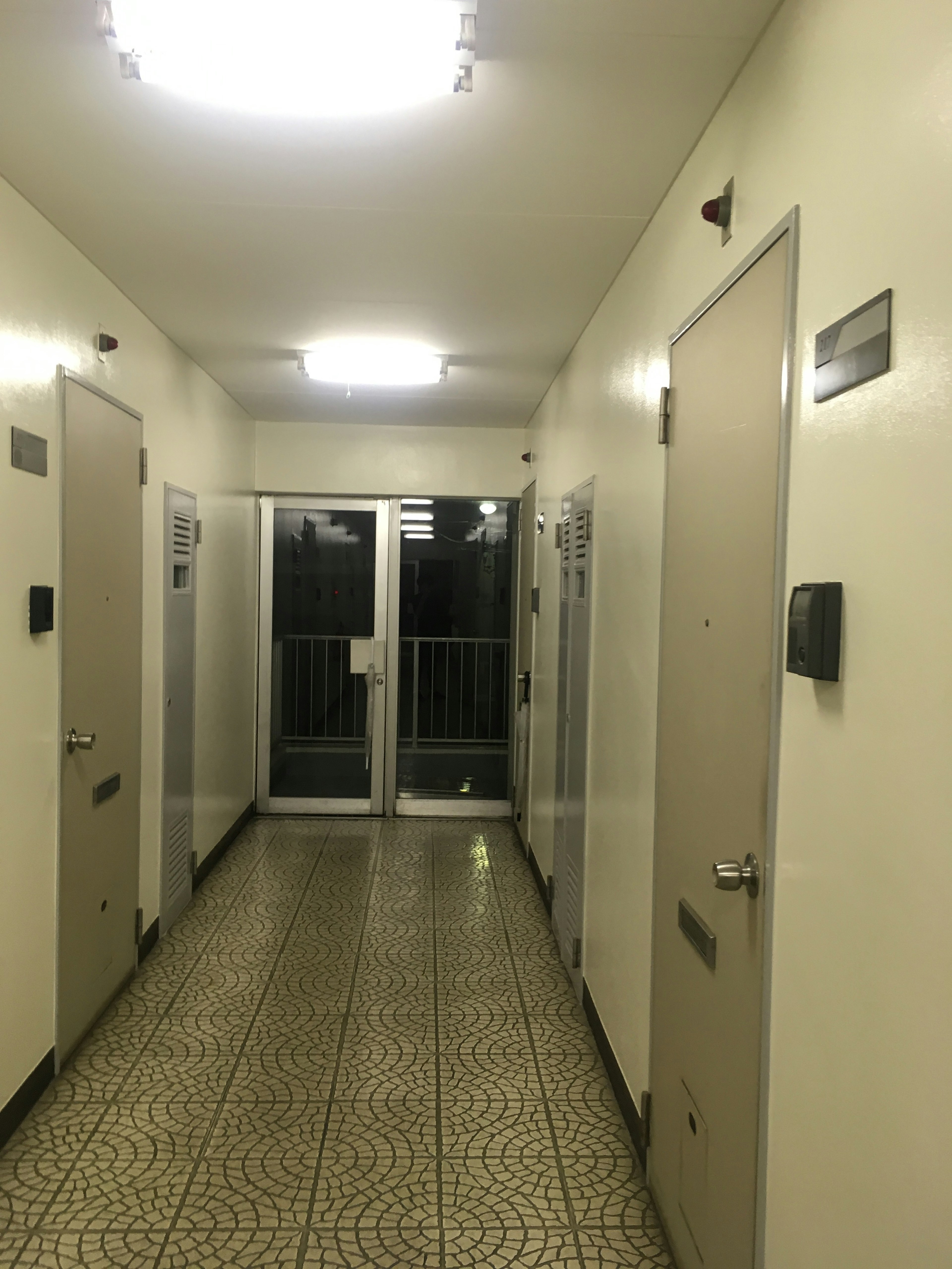 Nighttime corridor scene with bright lighting and lined doors