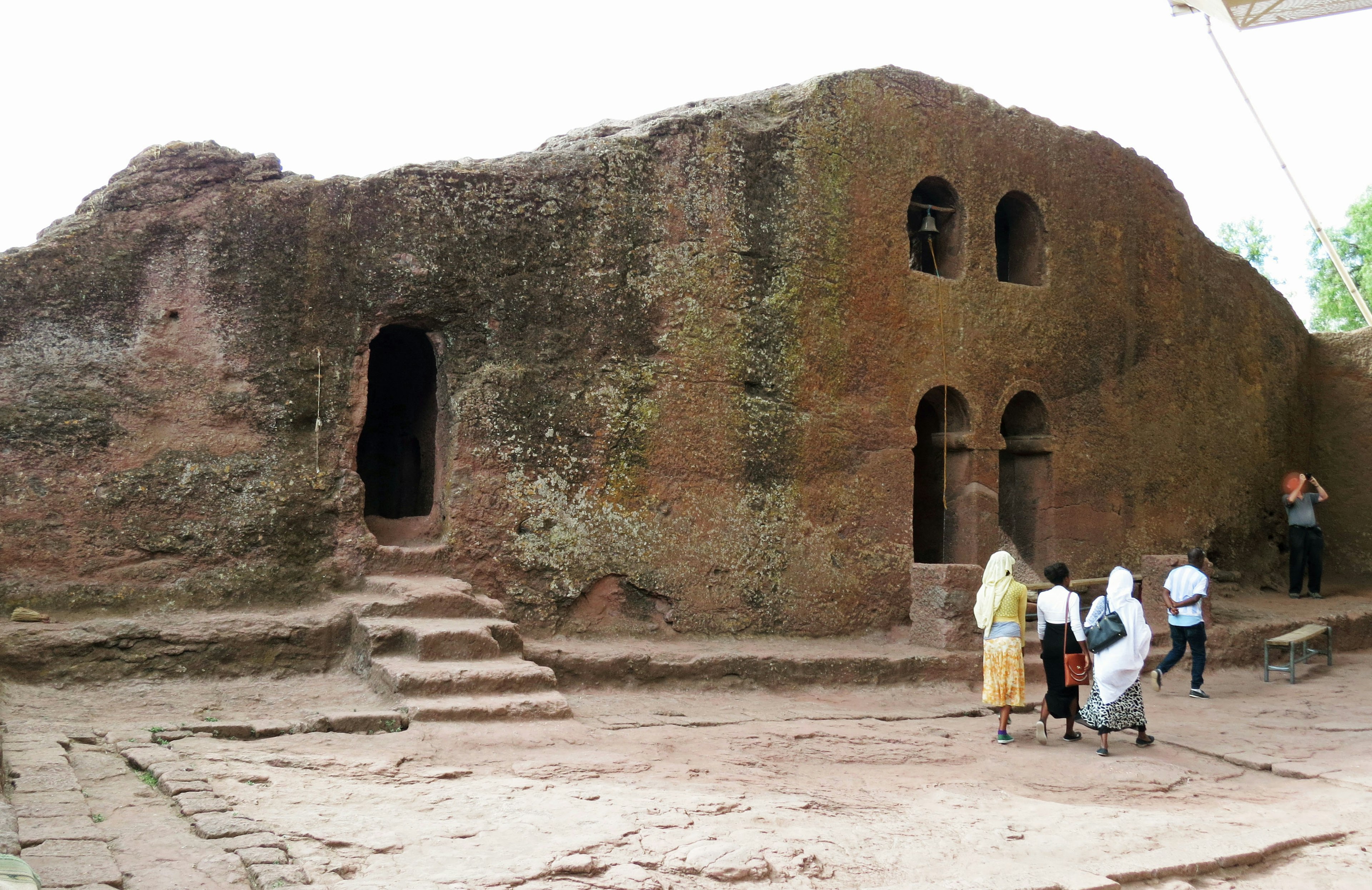 Rovine di una chiesa scavata nella roccia a Lalibela in Etiopia con visitatori