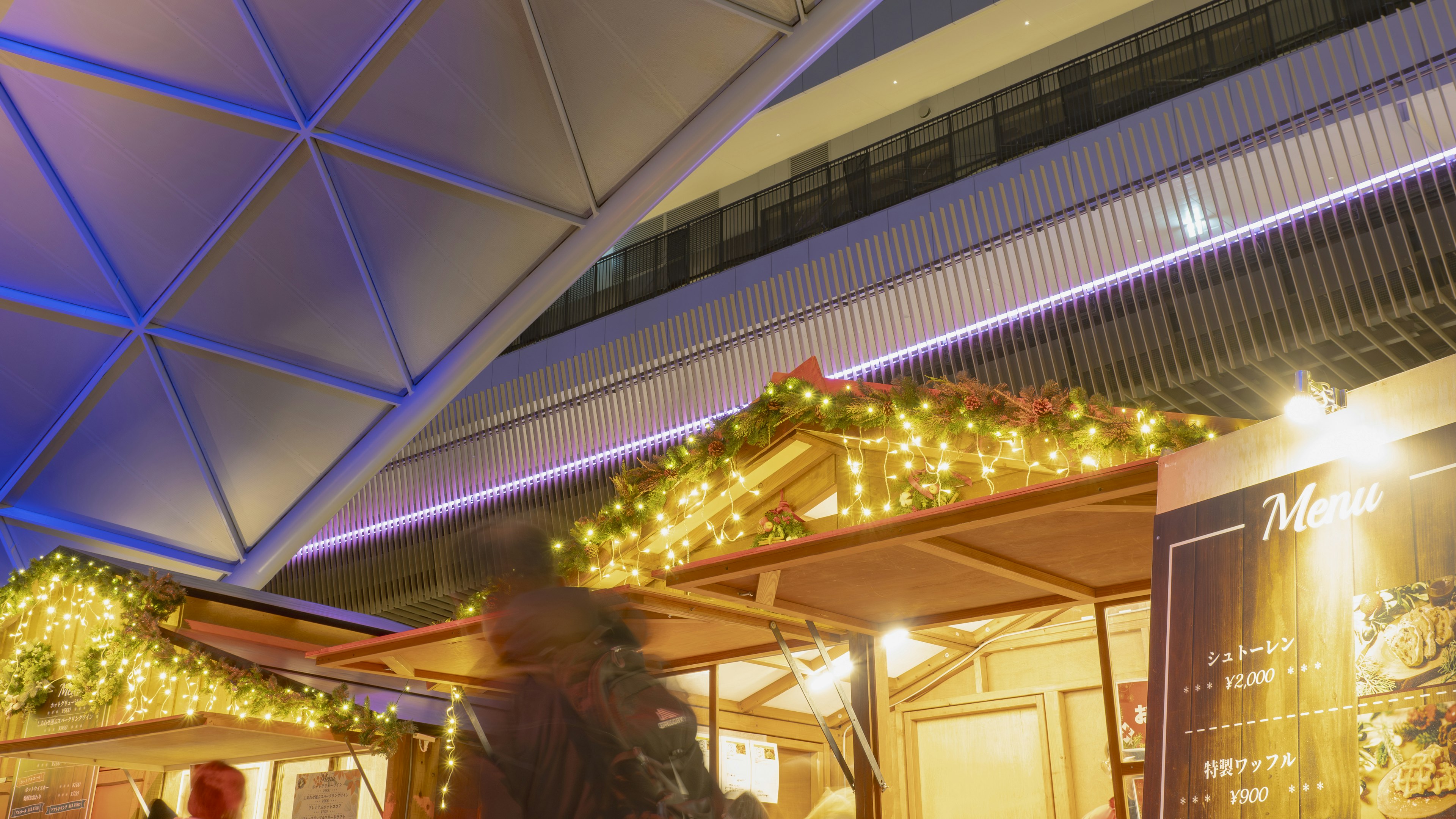 Stand de marché de Noël avec des lumières vives et un toit décoré