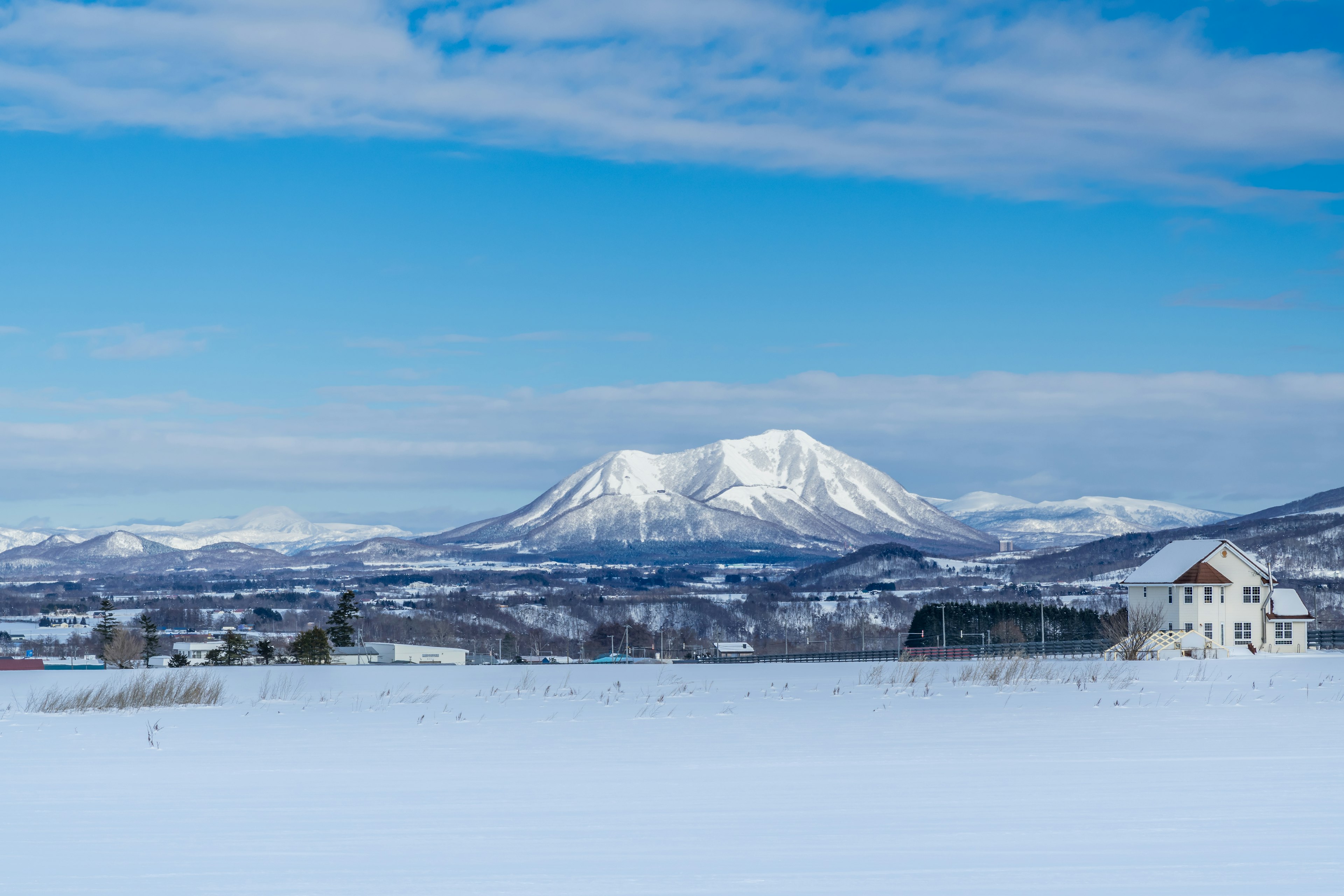 Snow-covered landscape with mountains under a blue sky