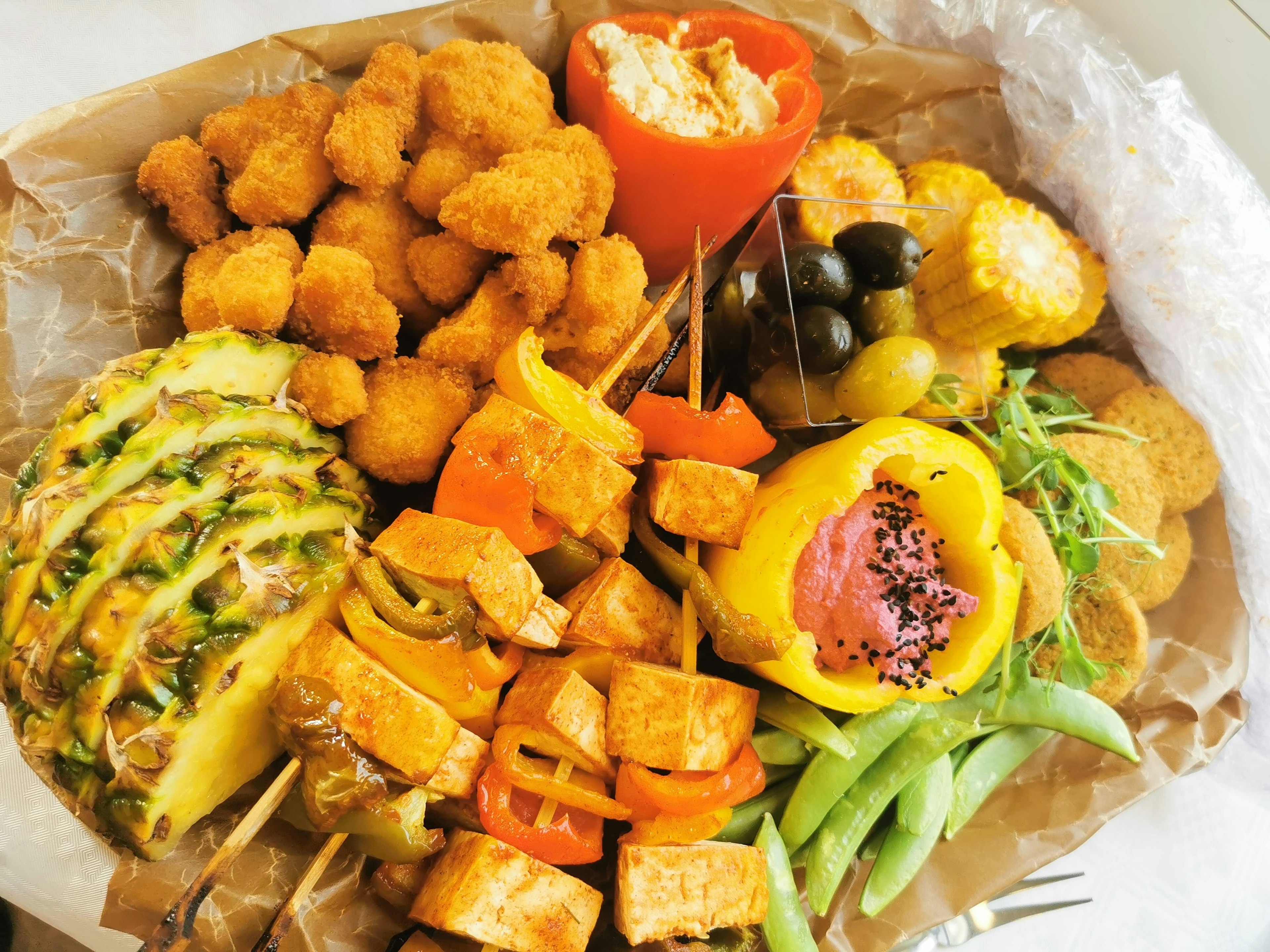 A vibrant platter featuring assorted vegetables and fruits including fried chicken and bell peppers