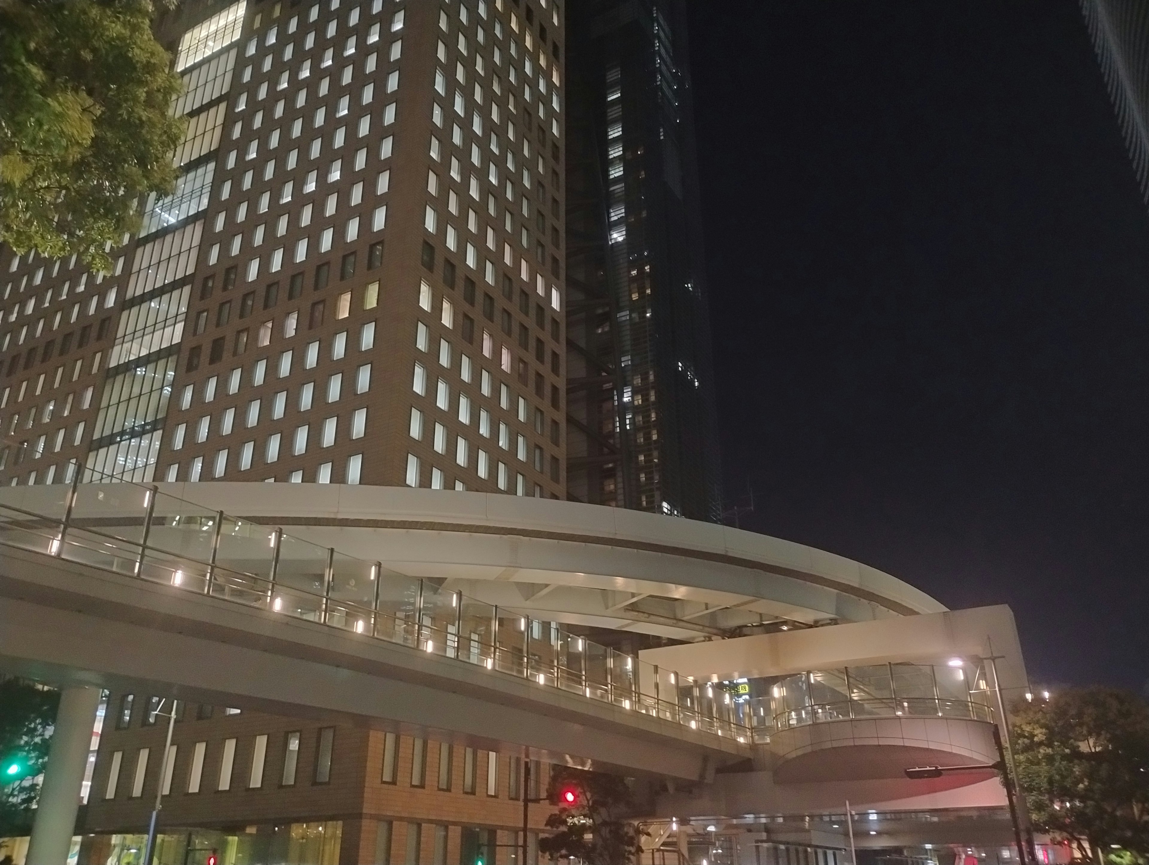 Modern urban building at night with illuminated pedestrian bridge