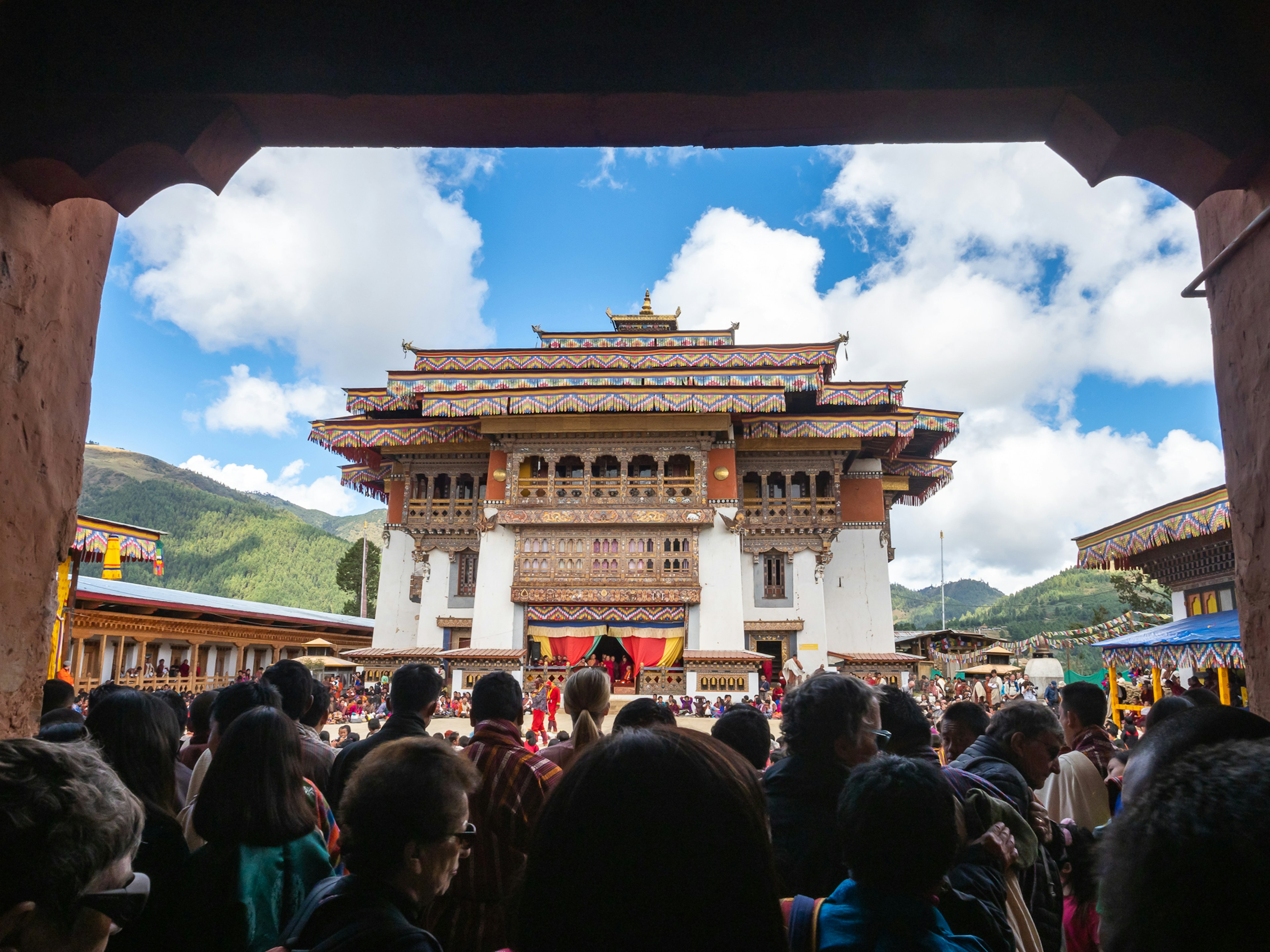 Menschenmenge versammelt vor einem traditionellen bhutanischen Tempel mit einem schönen blauen Himmel