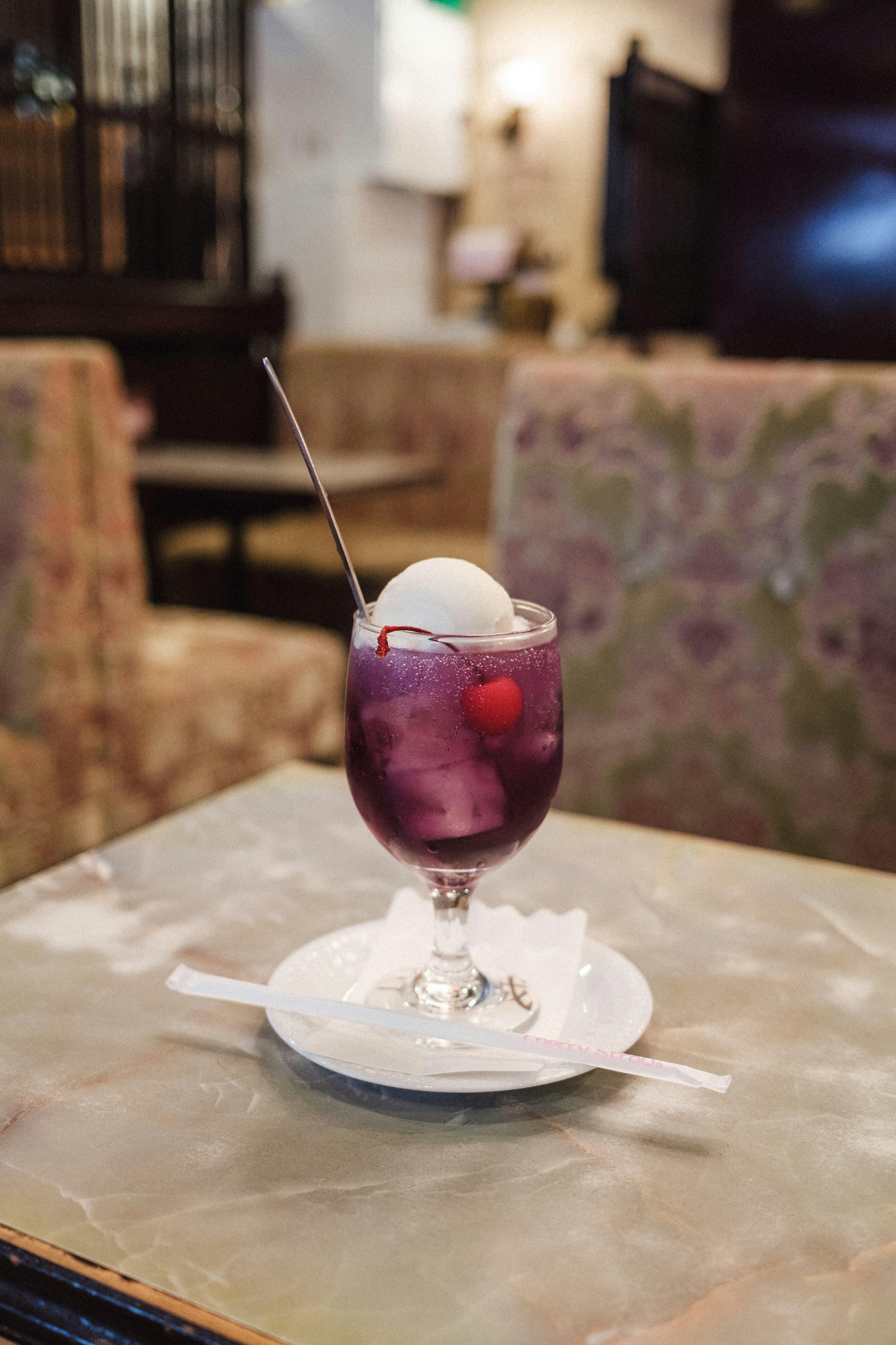 A glass of purple drink topped with ice cream