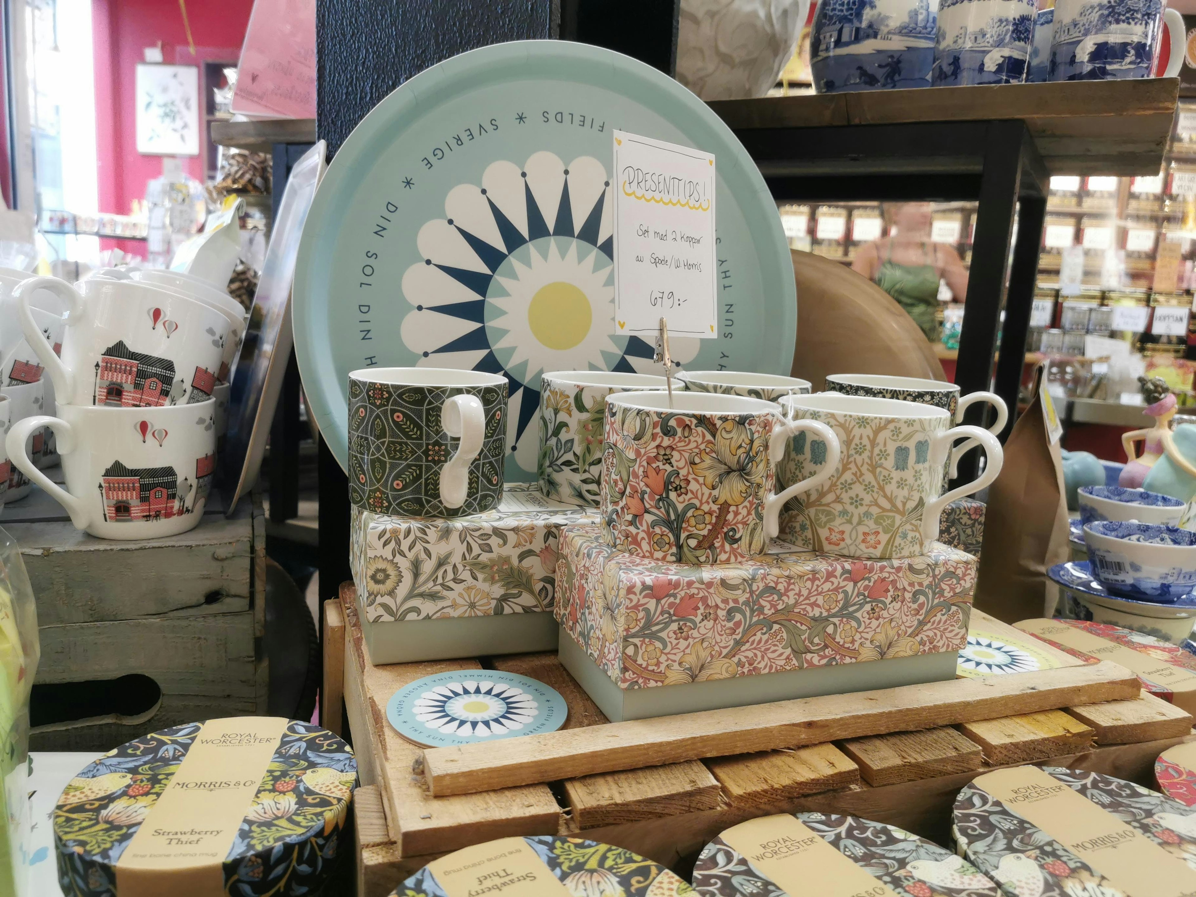 Colorful patterned mugs and plates displayed in a store